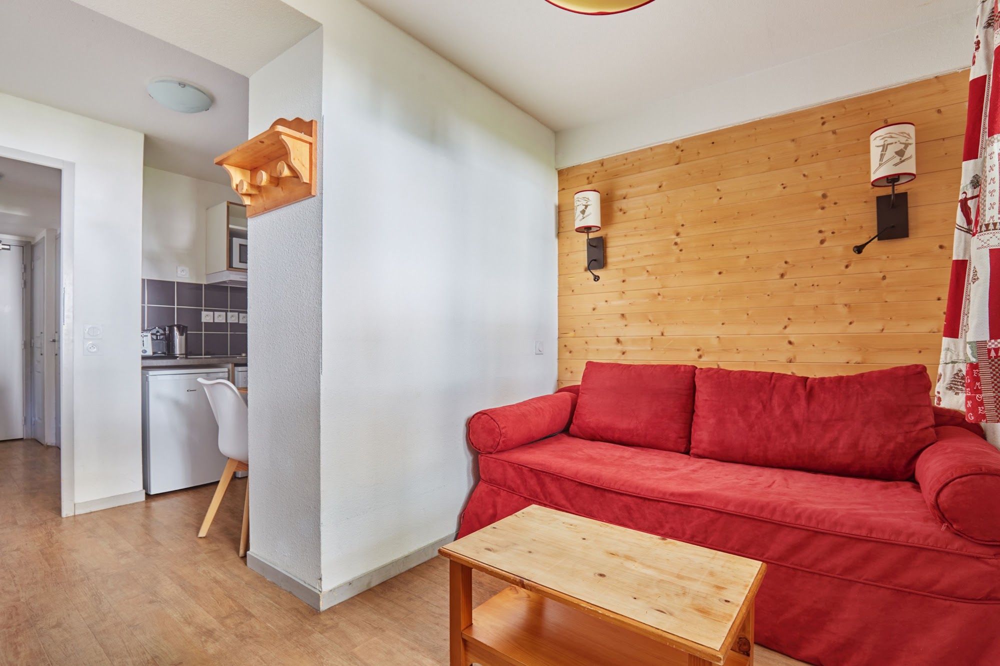image Living area with a red sofa and a small wooden table