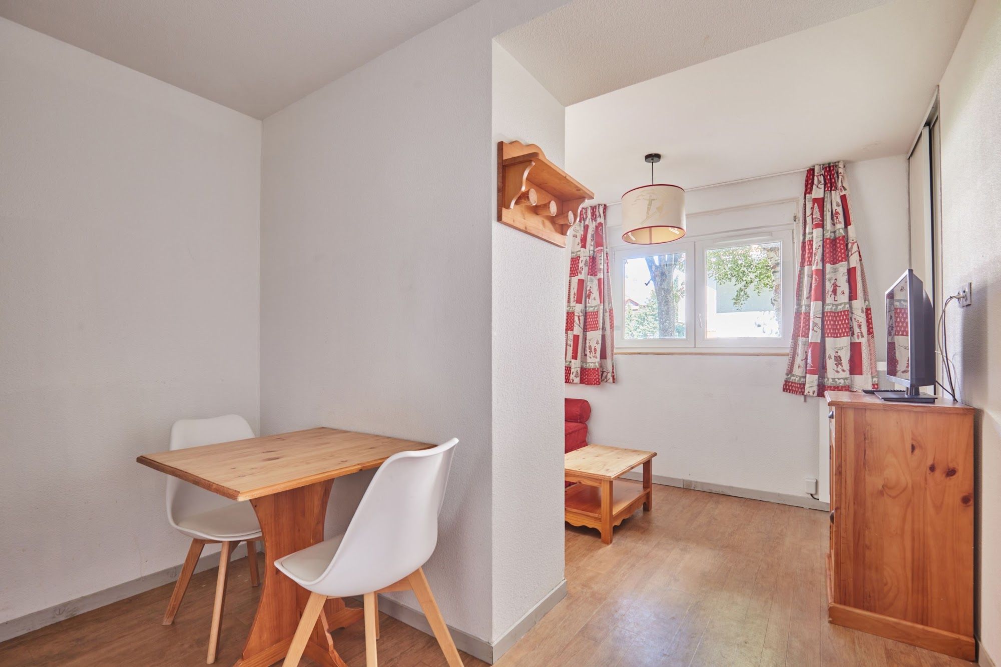image Dining table and chairs by the windows, with a TV unit