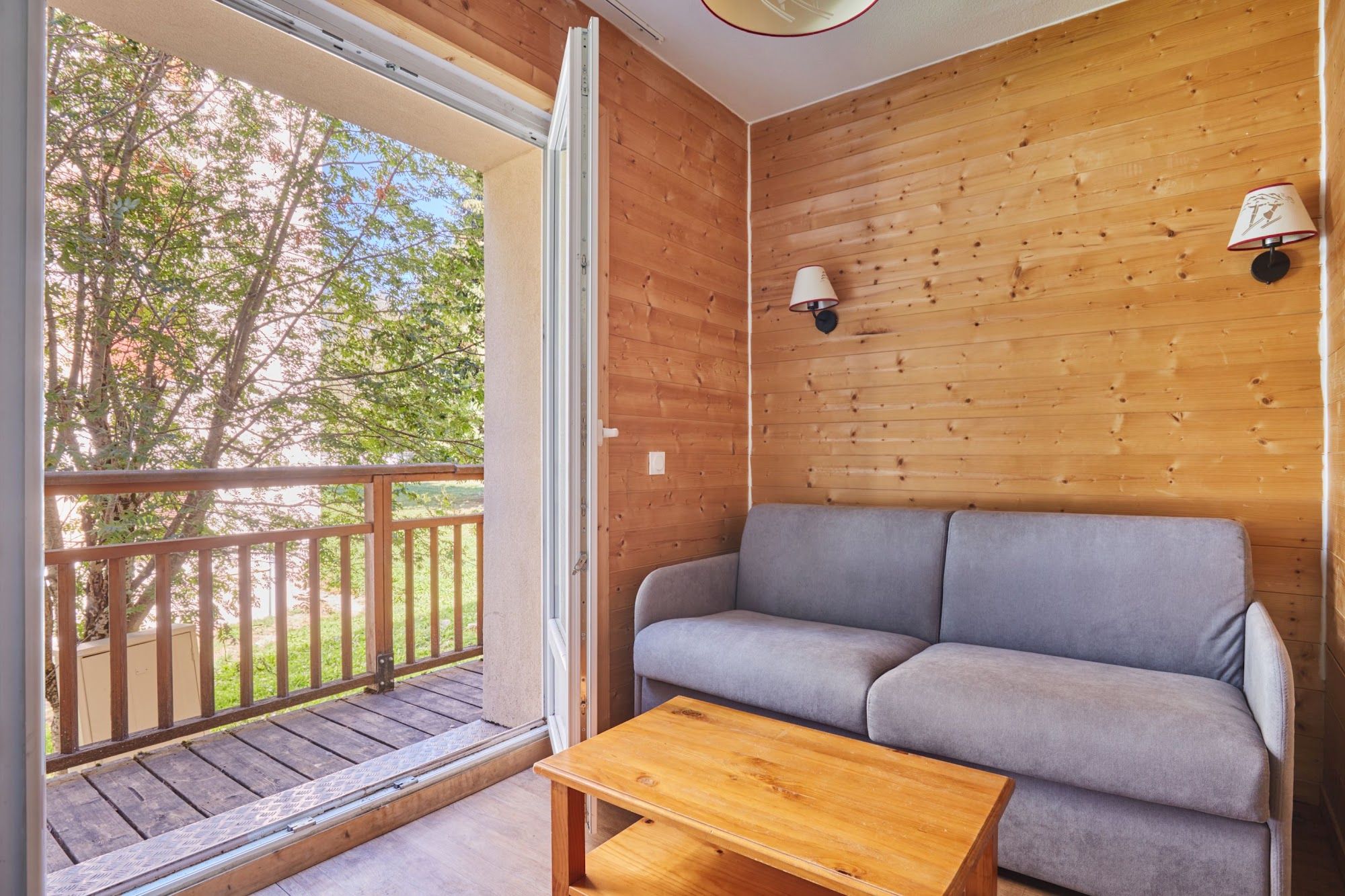 image Sofa bed and wooden table beside the balcony door