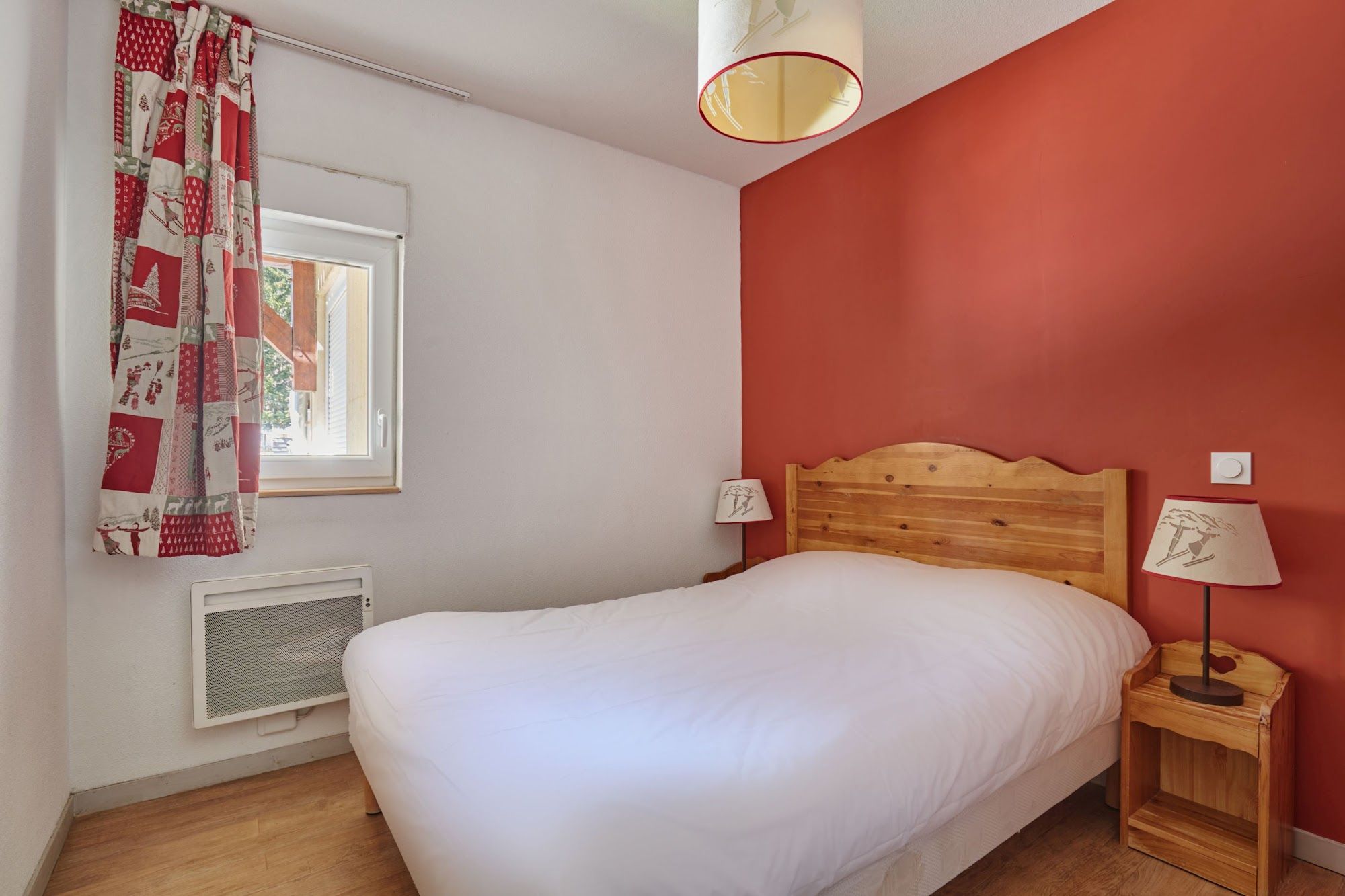 image Bedroom with a double bed, a red accent wall and patterned curtains