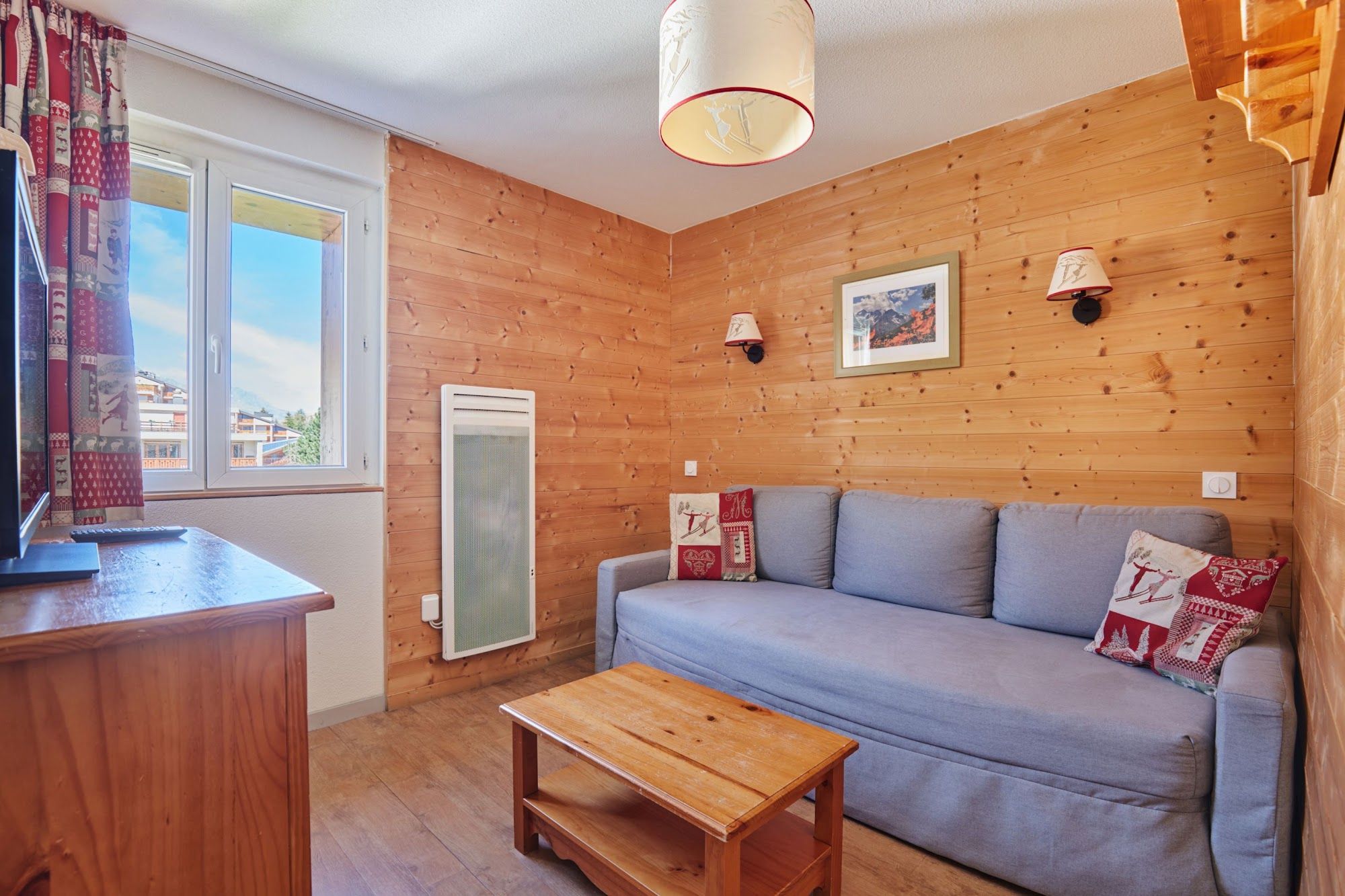 image Living room with a sofa bed, wooden table and TV