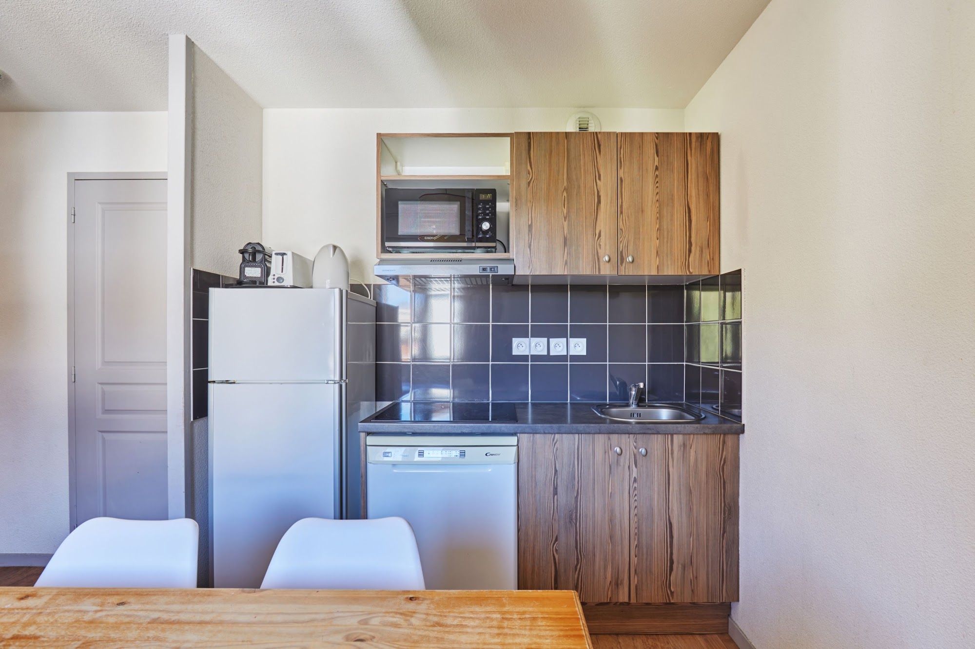image Kitchenette with a fridge and microwave beside the dining table