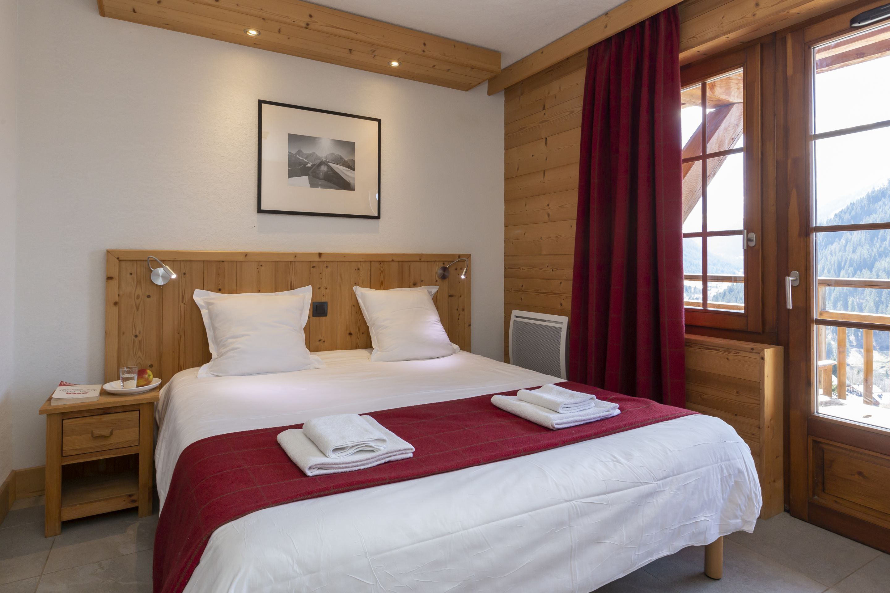 image The double bedroom with warm linens made up on arrival and a mountain view framed by the window.