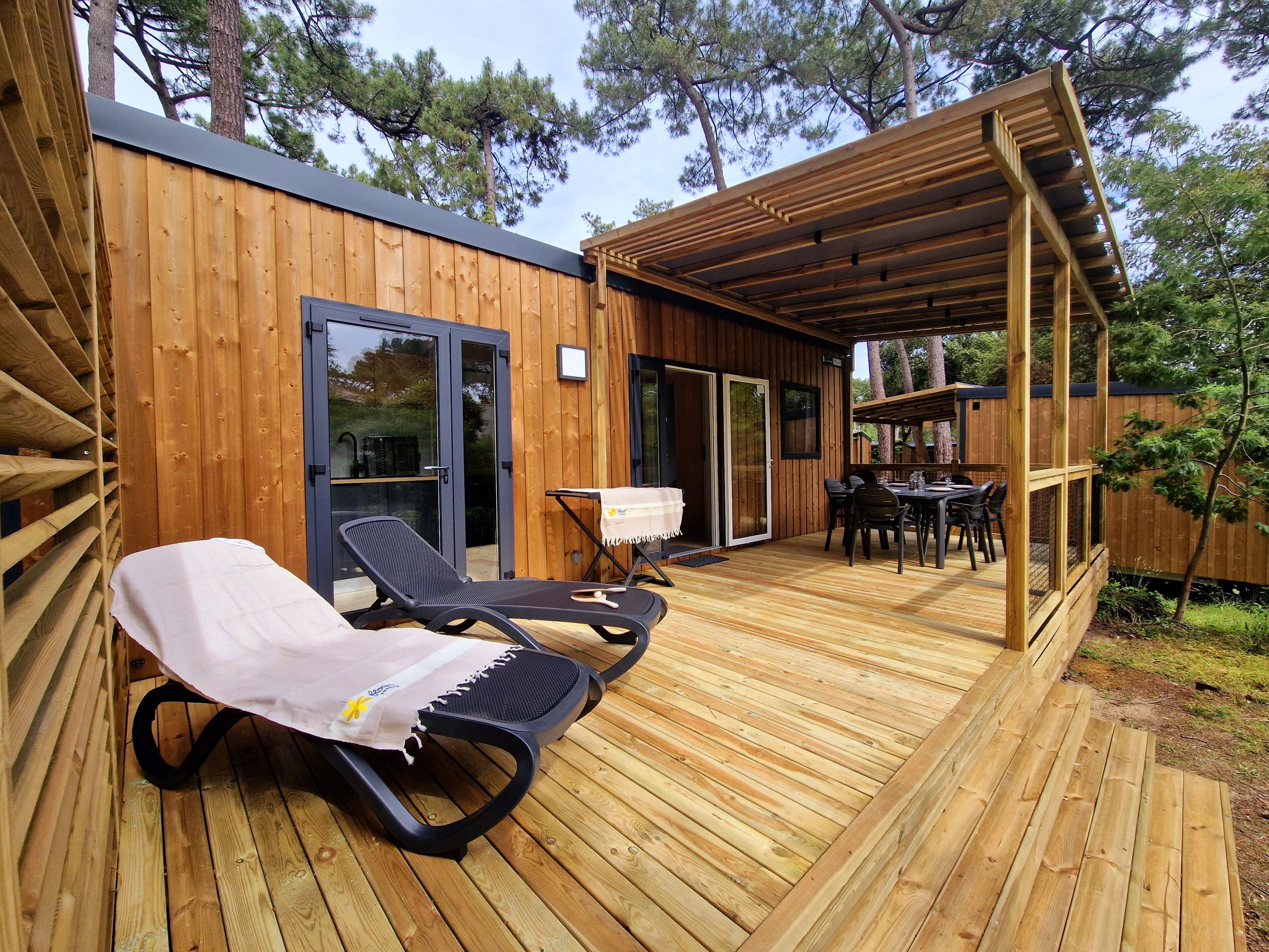 image Savor meals in the fresh air on your private patio, equipped with a plancha grill. The spacious table provides a peaceful setting right in the heart of your cosy mobile home retreat.