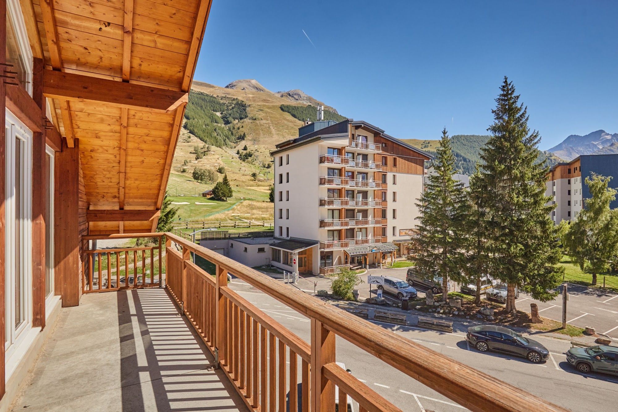 image Balcony with a wooden railing overlooking mountains and trees