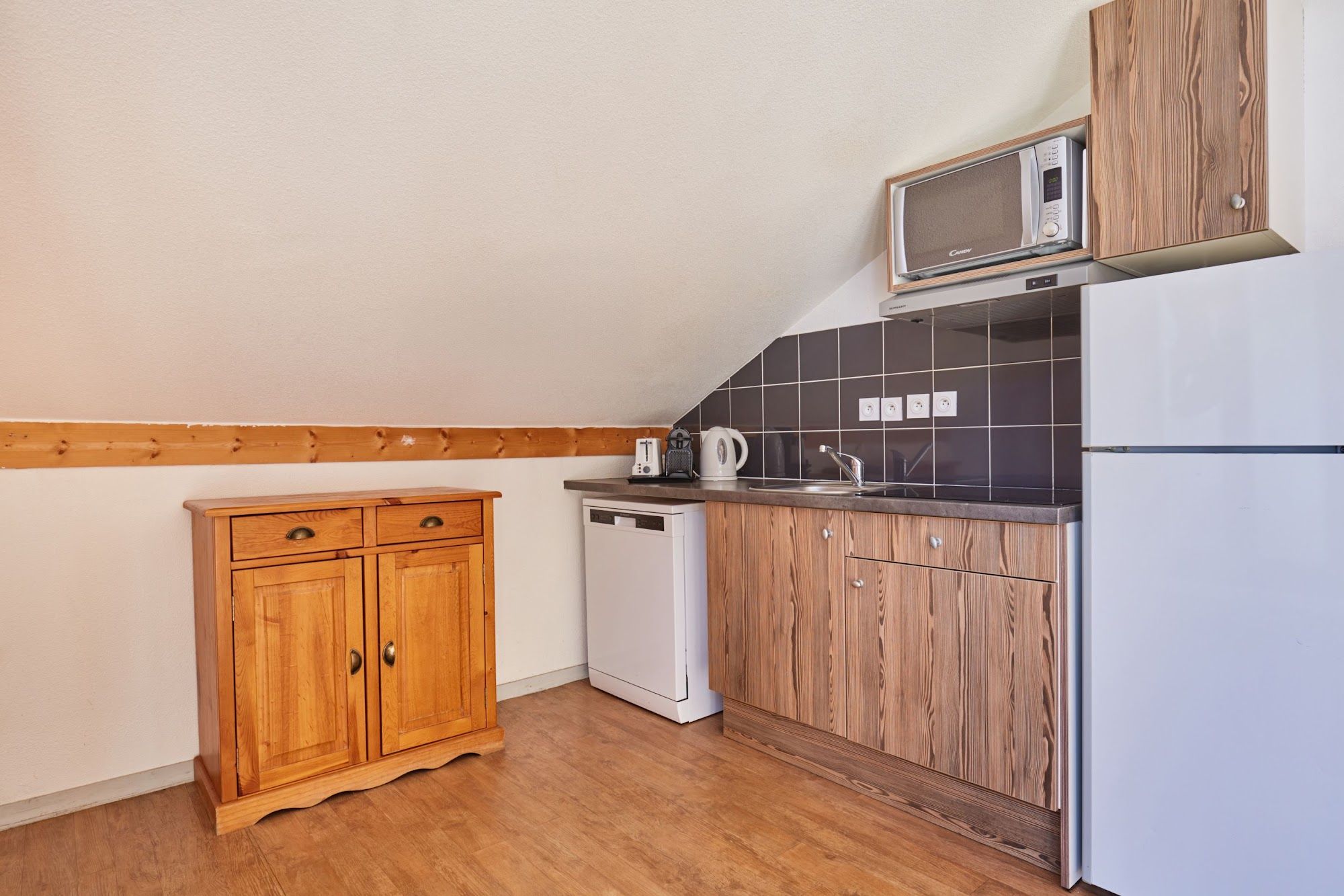 image Kitchenette with wooden cabinets, microwave and dishwasher