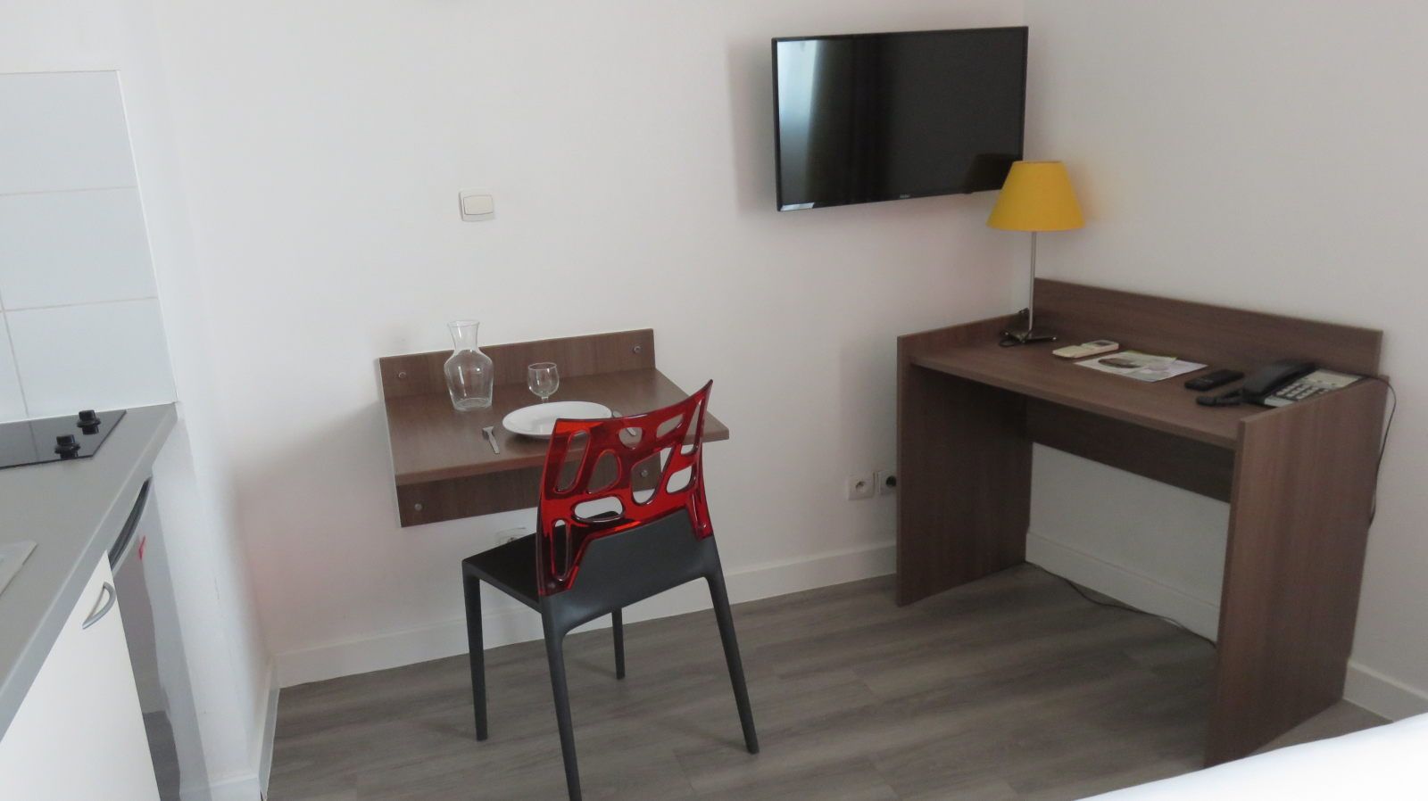 image Workspace includes a small table set for one with cutlery and a TV mounted on the wall