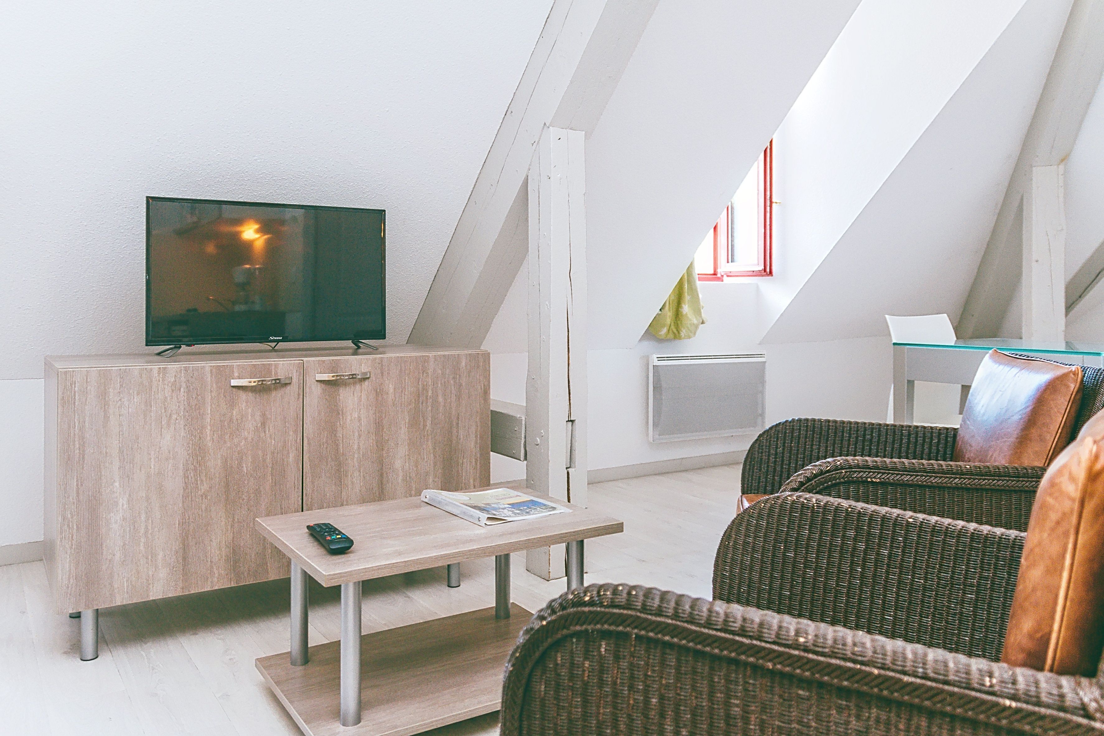 image Living space with a TV and two armchairs.