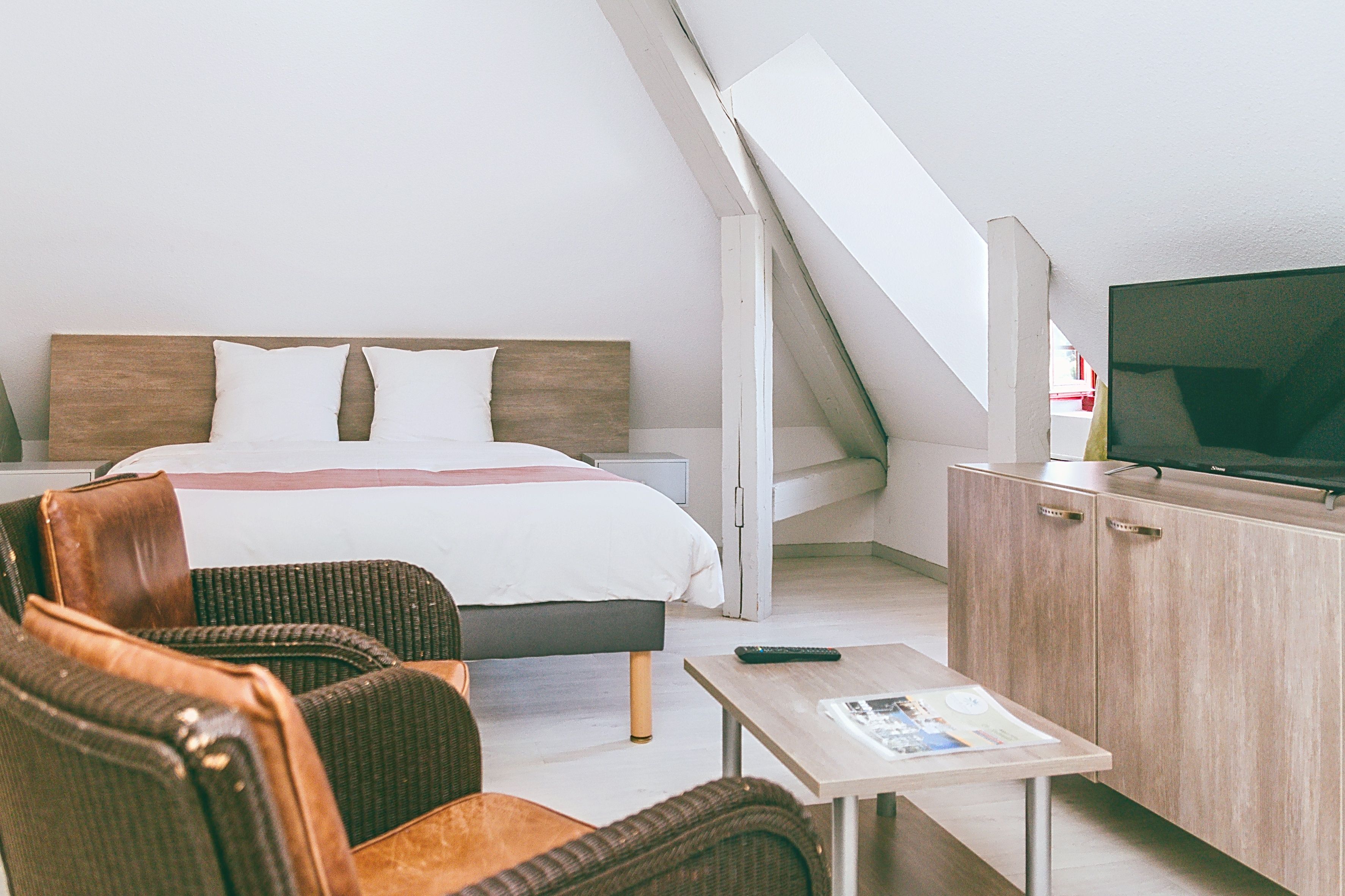 image Attic-style room with a double bed and TV.