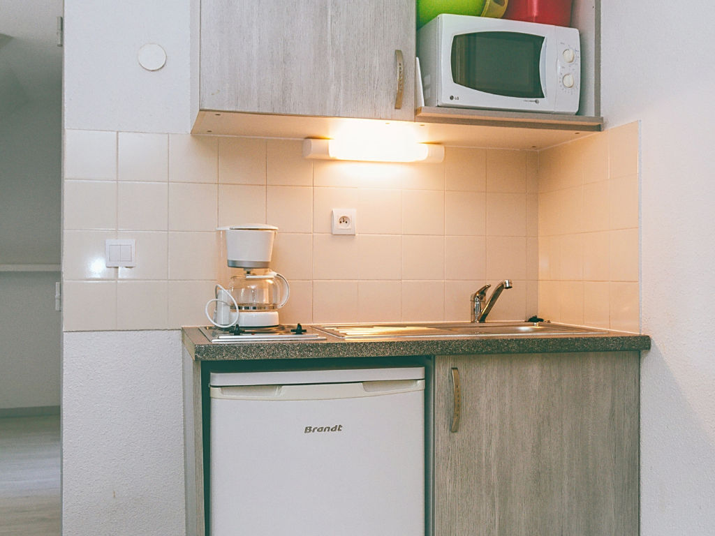 image Kitchen corner with sink, coffee maker, and mini fridge.