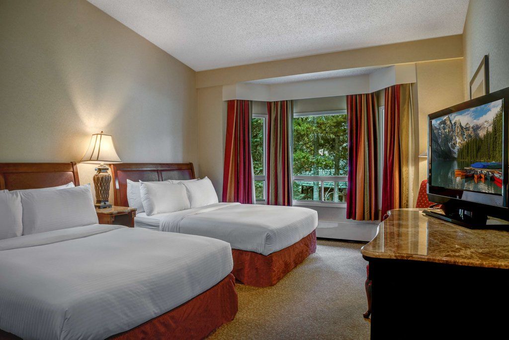 image Relax to a Deluxe Hotel Room with 2 Queen beds.