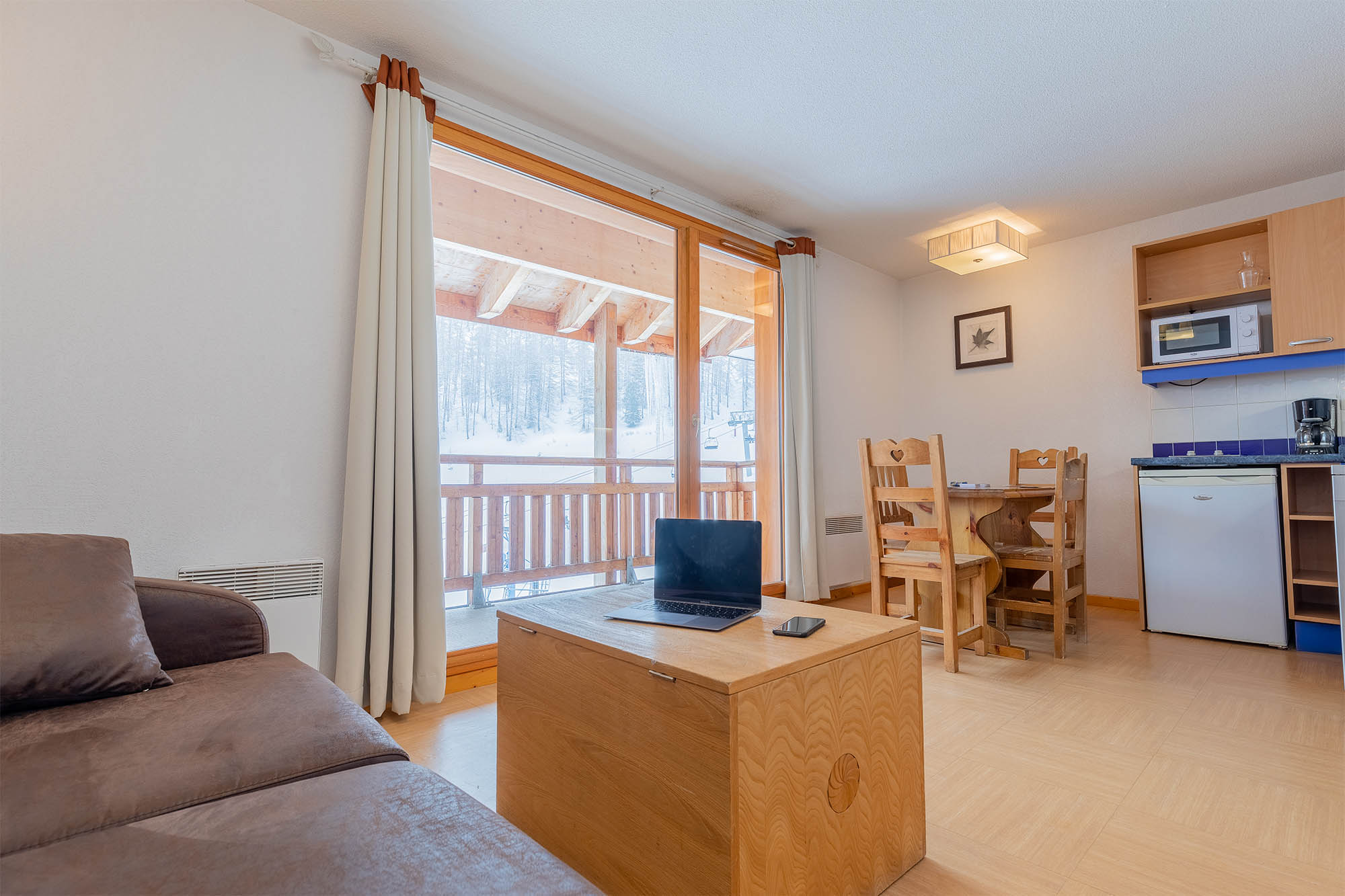image Living area and kitchen with a view of the snowy landscape