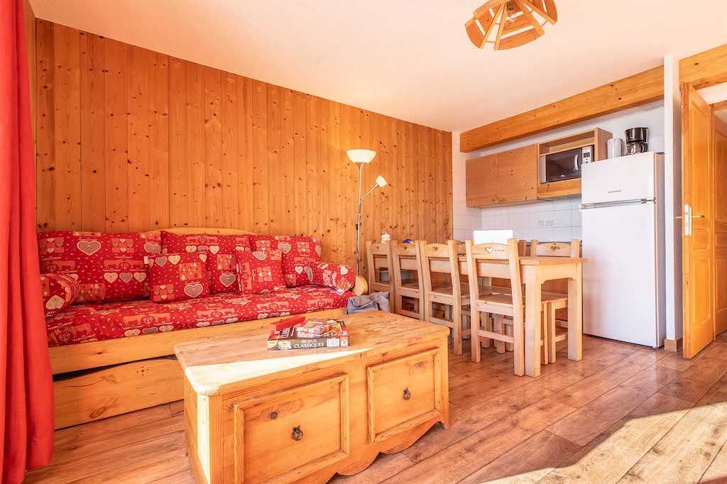 image The inviting living area, adorned with colorful cushions and wooden decor, provides a cozy space for relaxation and socializing, complemented by views of the beautiful alpine landscape.