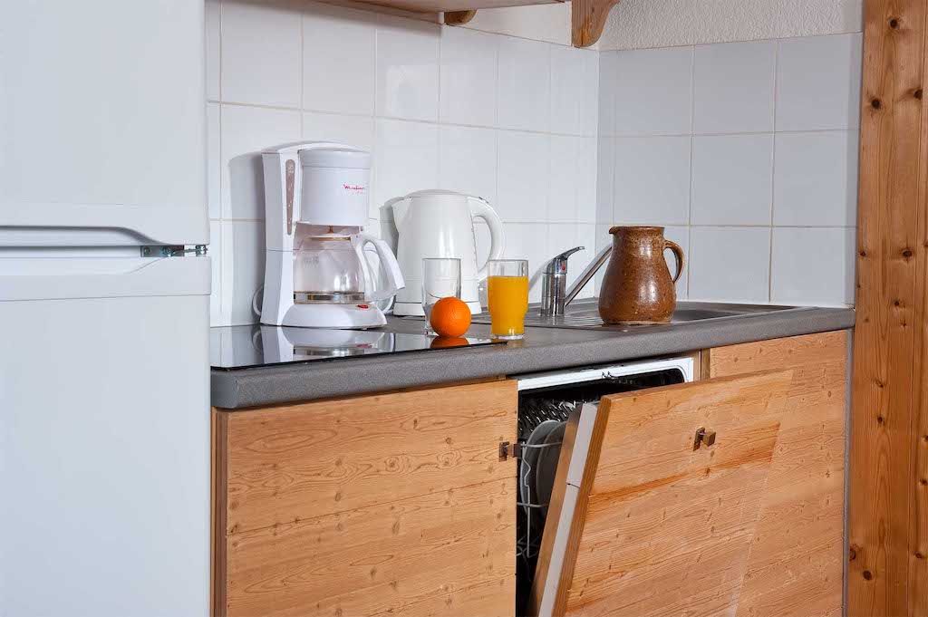 image A well-equipped kitchen showcases a blend of modern appliances and rustic wooden cabinetry, inviting guests to prepare warm meals after a day on the slopes.
