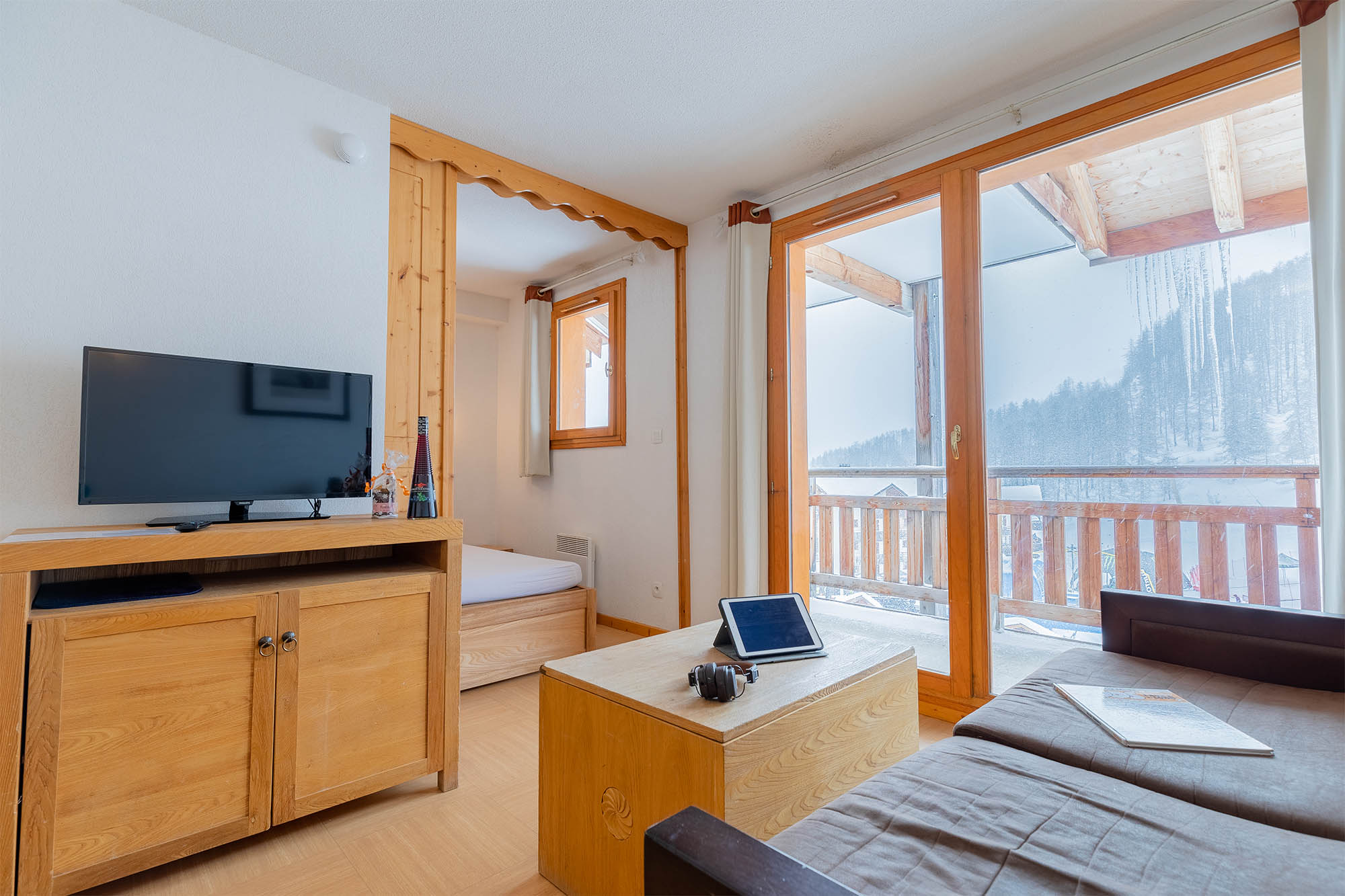 image Living area with TV, single bed and balcony view