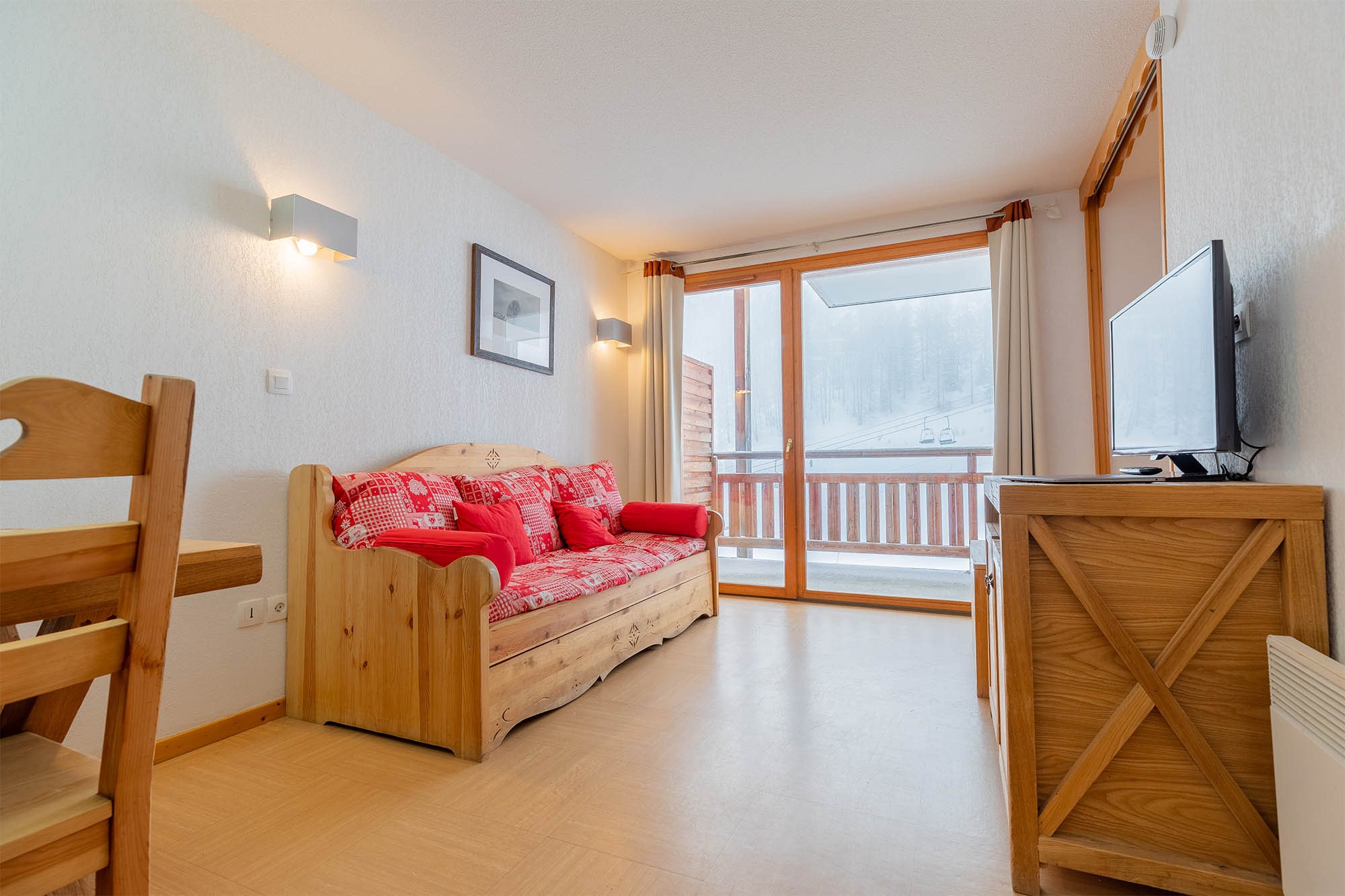 image Living area with sofa bed, TV and balcony view