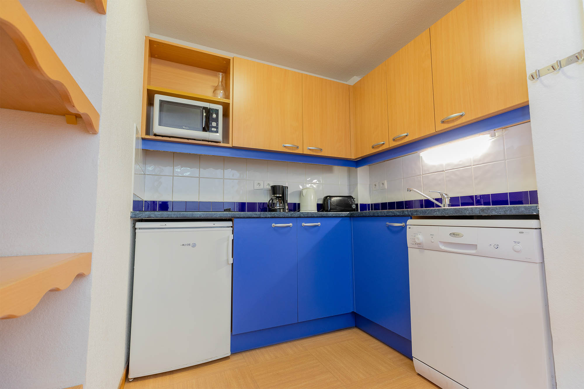 image Kitchen with blue cabinets, microwave and refrigerator