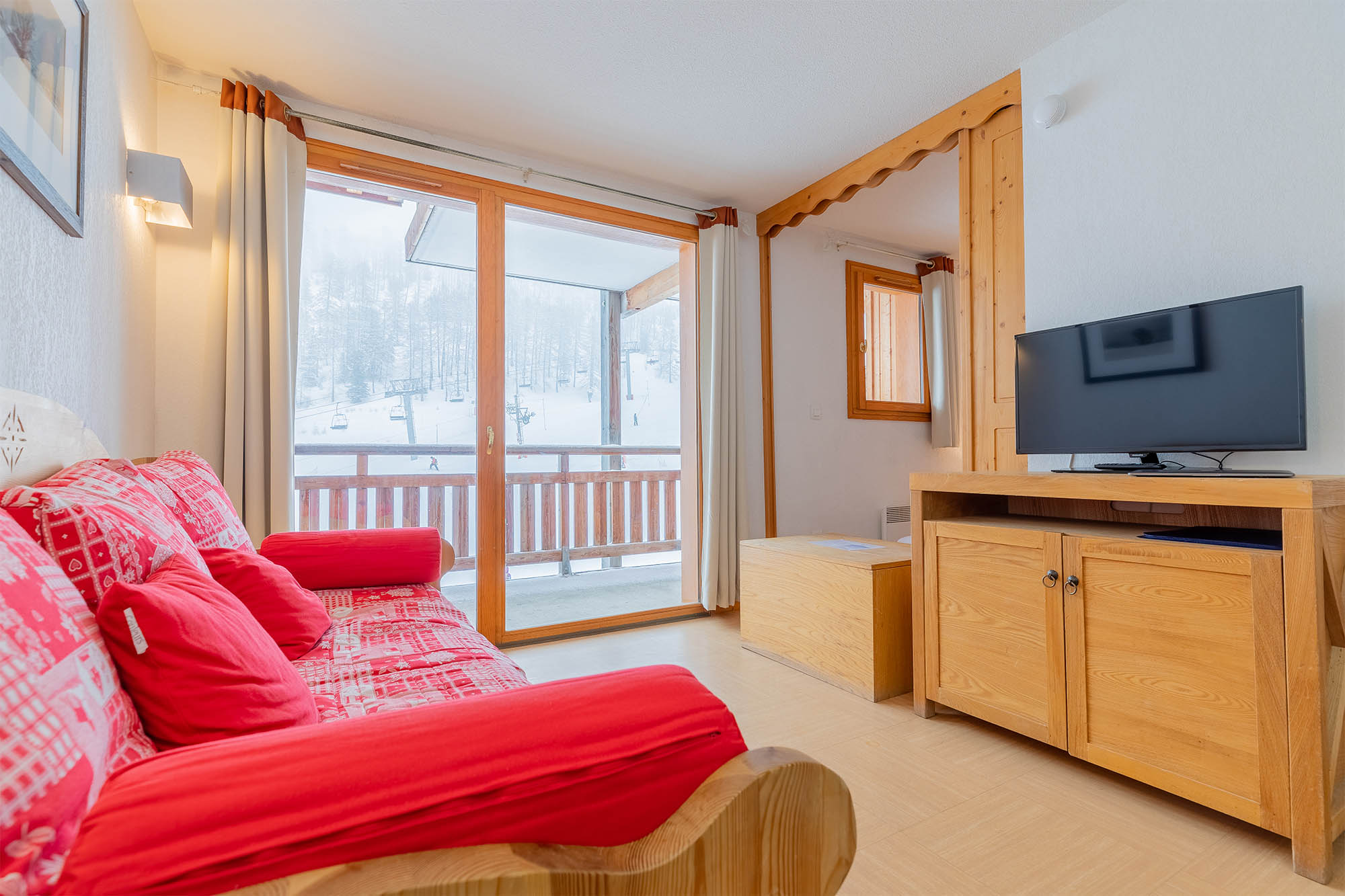 image Living area with sofa bed, TV and balcony doors