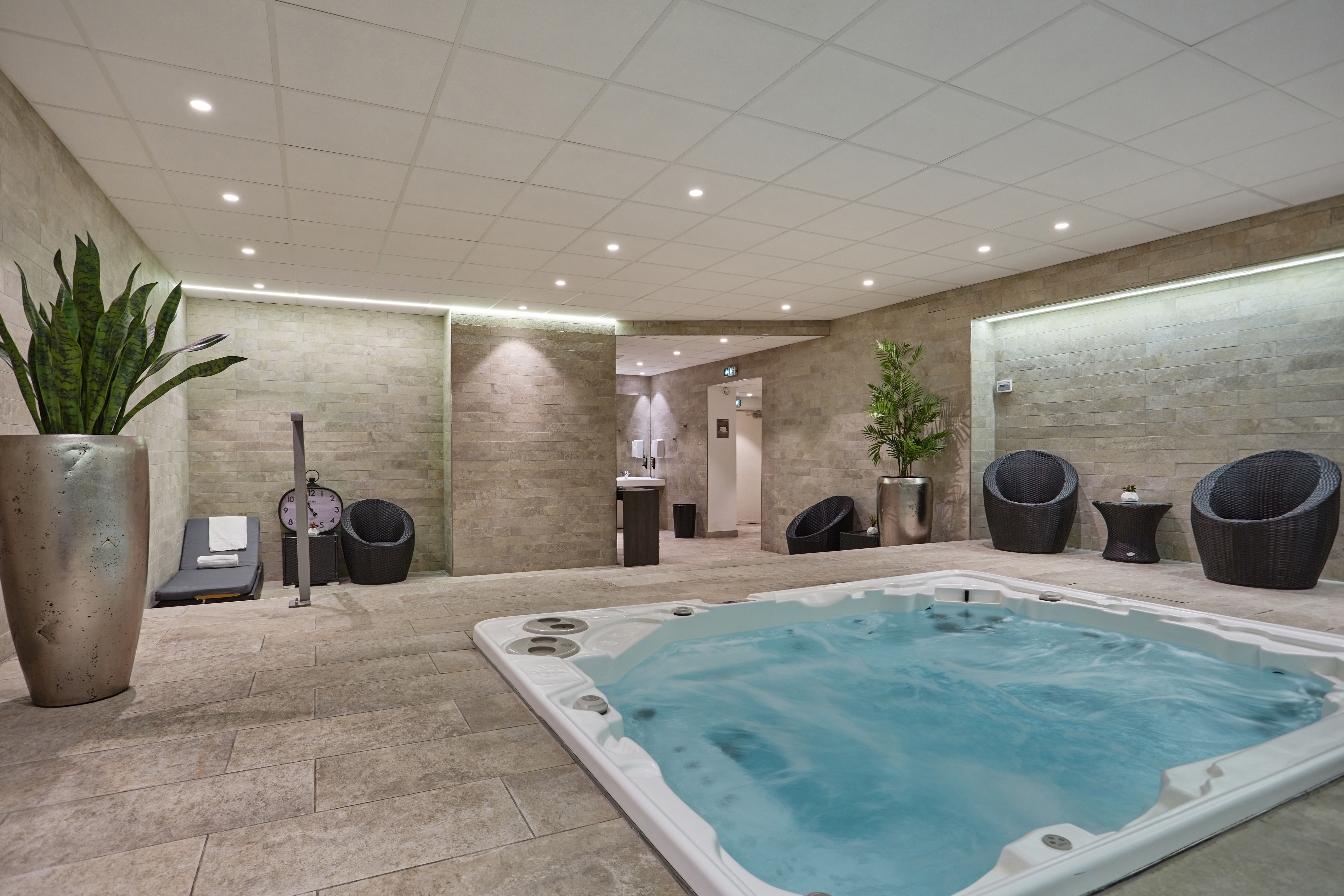 image Relaxing shared spa zone with jacuzzi and lounge seating, accessible on-site at the residence.