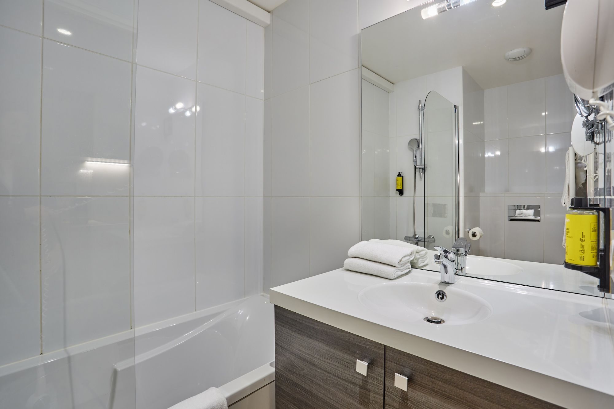 image Stylish bathroom with modern vanity, clean white fixtures, and inviting tile accents.