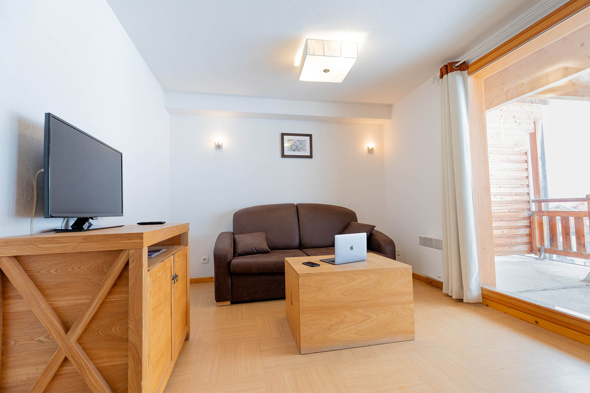 image Living area with TV, sofa bed and balcony access