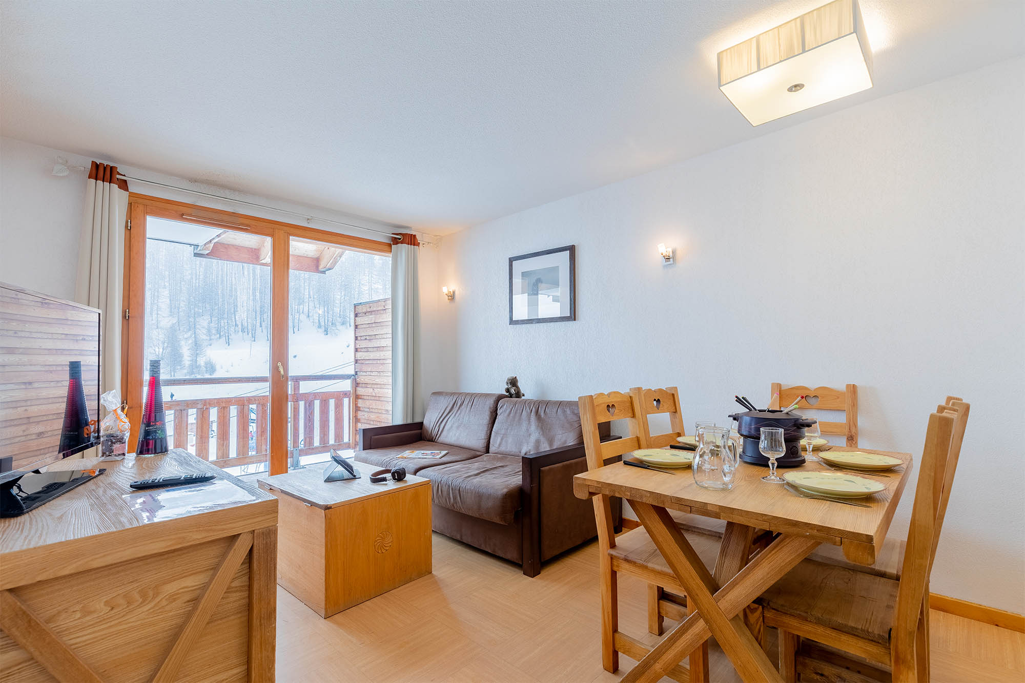 image Living area with sofa bed, dining table, TV and balcony view