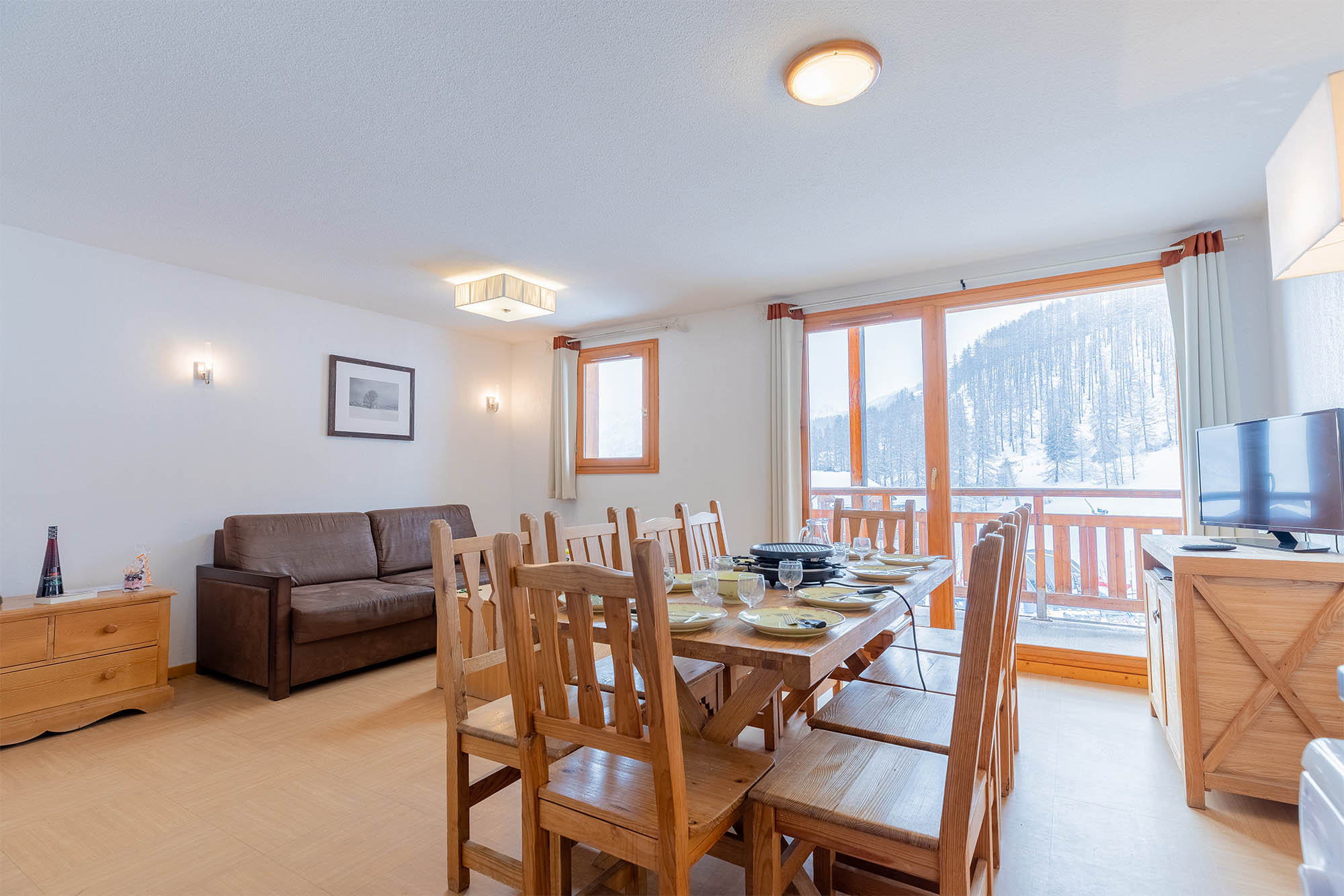 image Living area with dining table, sofa bed and large windows