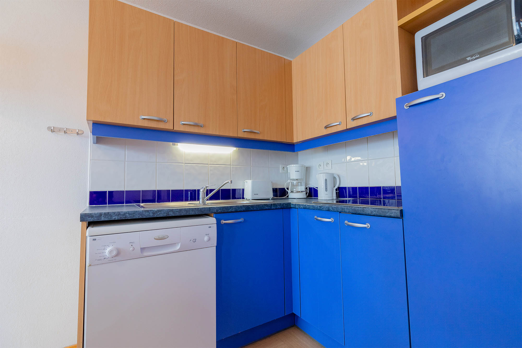 image Kitchen with blue cabinets and dishwasher