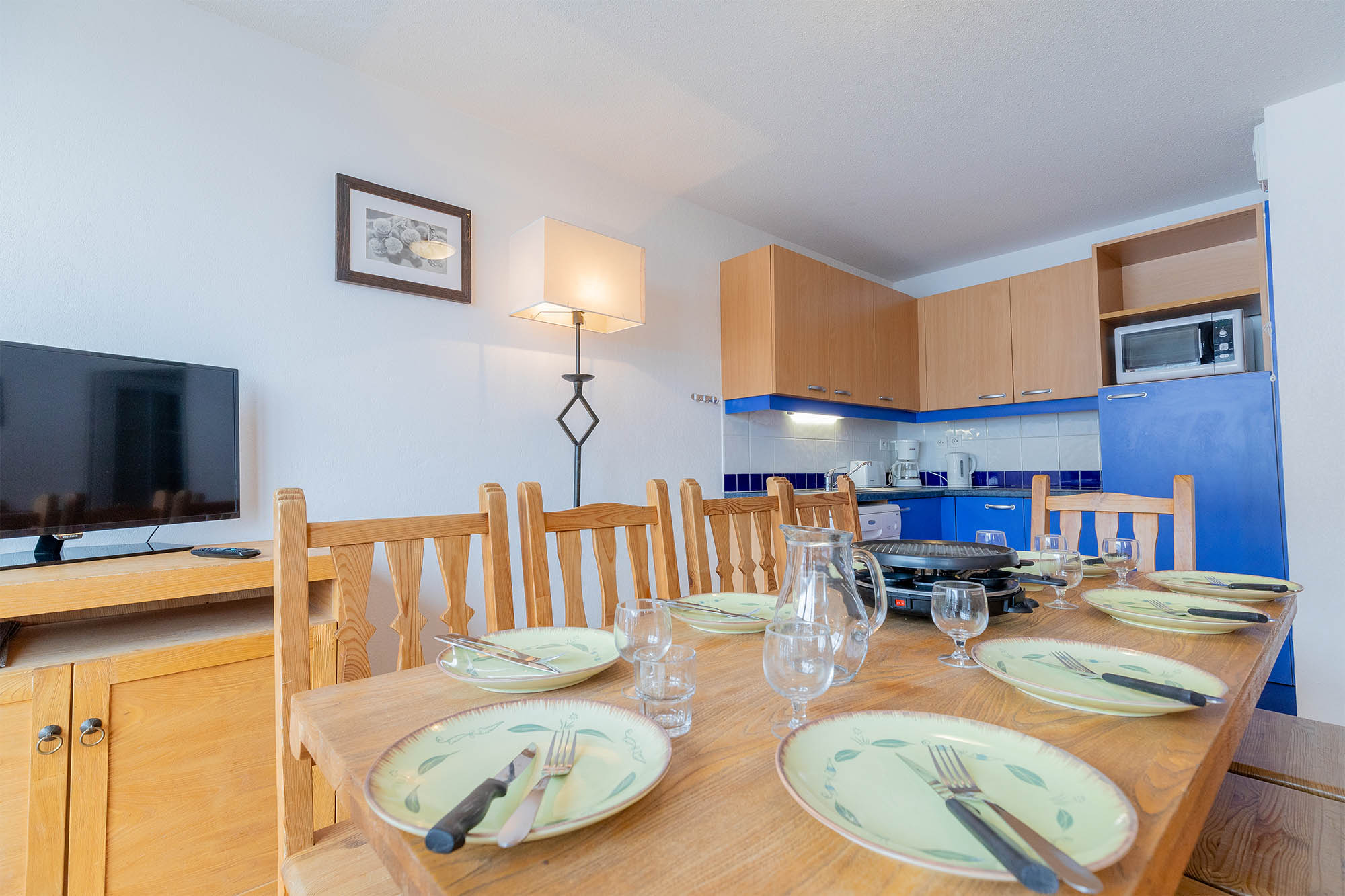 image Dining table set for a meal, with kitchen counter beyond