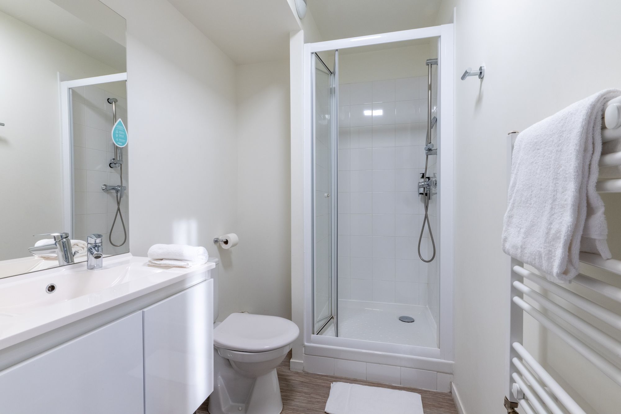 image A clean and modern bathroom equipped with a shower, vanity sink, and fresh towels.