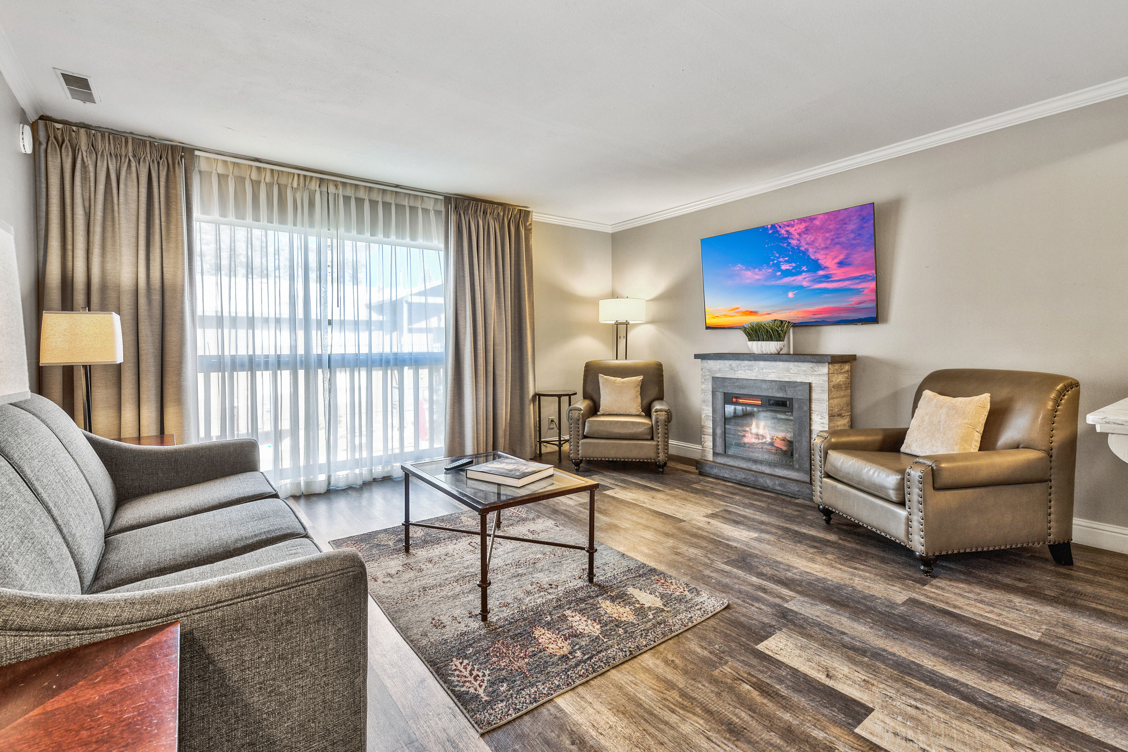 image A stylish and cozy living space featuring warm tones, plush seating, and a fireplace—ideal for relaxing evenings.
