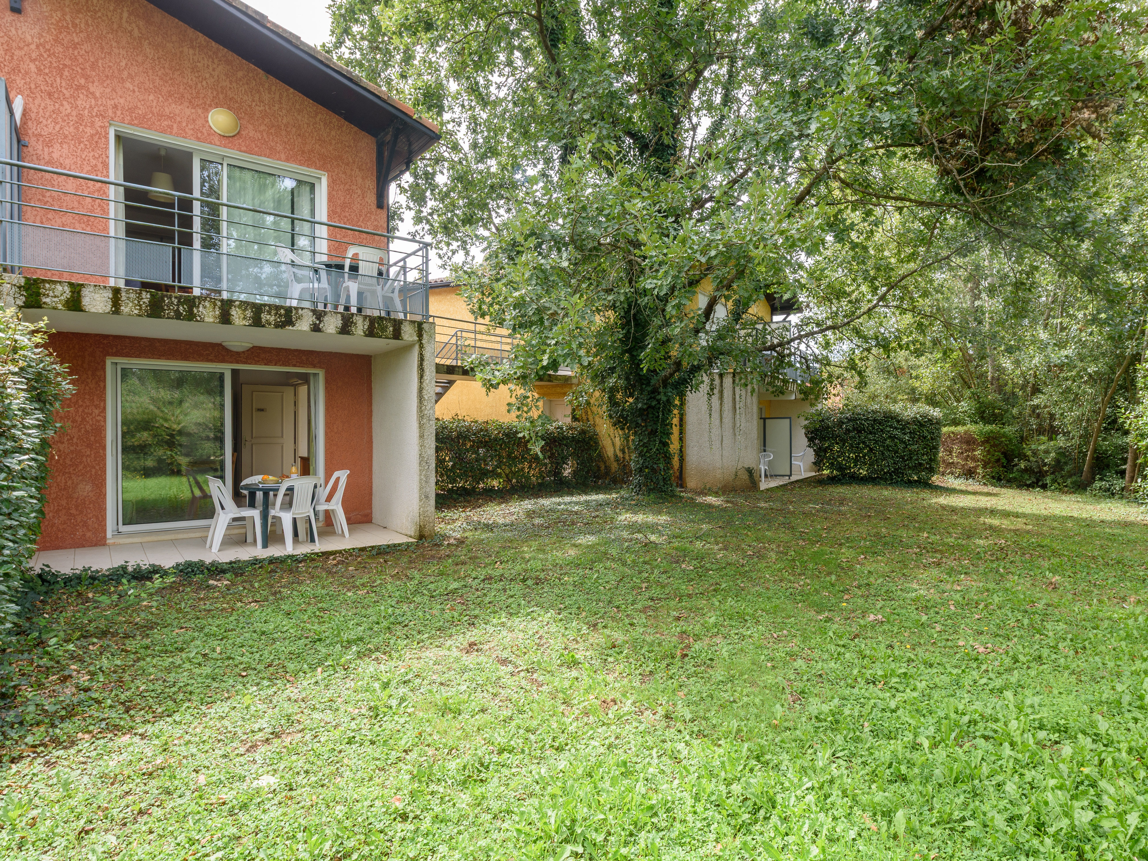 image Surrounded by vibrant flora, the apartment showcases a charming exterior while offering easy access to the relaxing outdoor area.