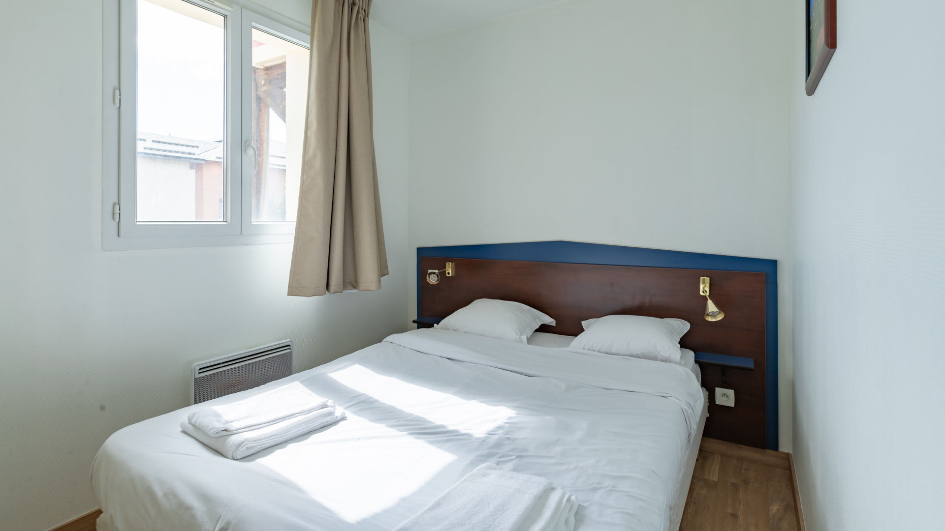 image Bright and comfortable room with a double bed and minimalist decor, designed for a peaceful and relaxing stay.