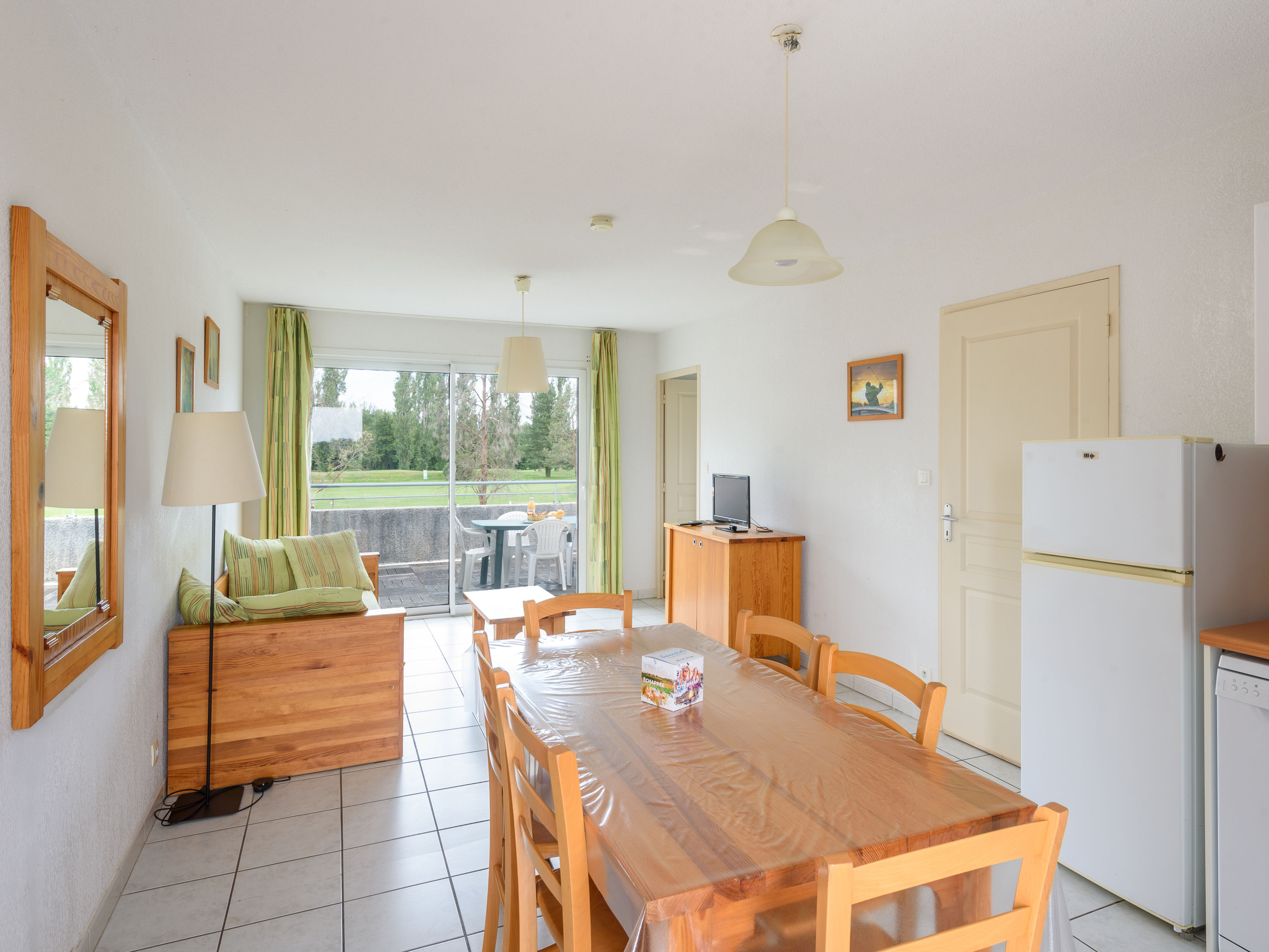 image The inviting living area features a cozy sofa, a dining table for communal meals, and large windows that allow natural light to brighten the space.