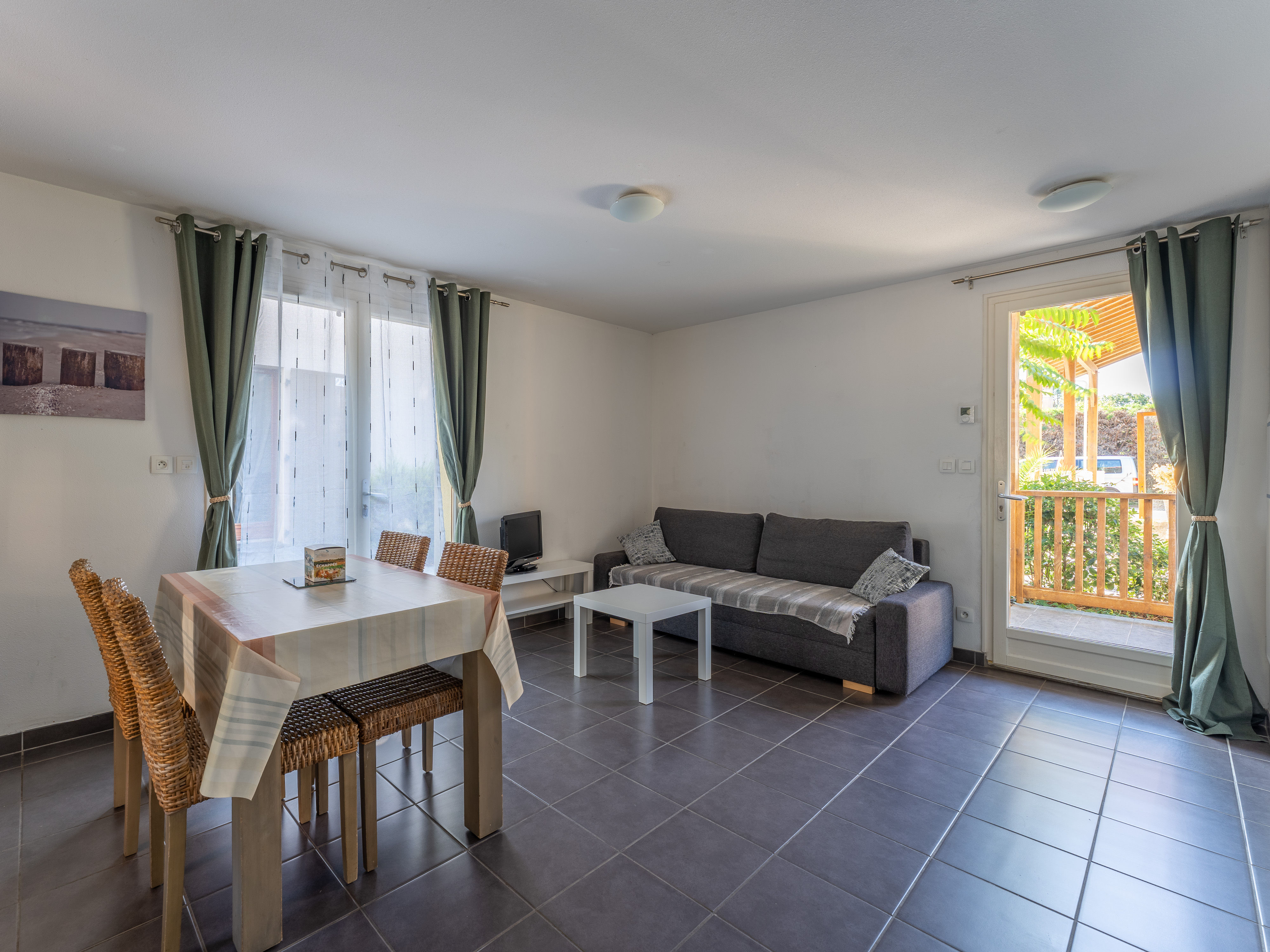 image The bright open living and dining space, with a sofa bed to comfortably sleep four and easy access to the terrace beyond.
