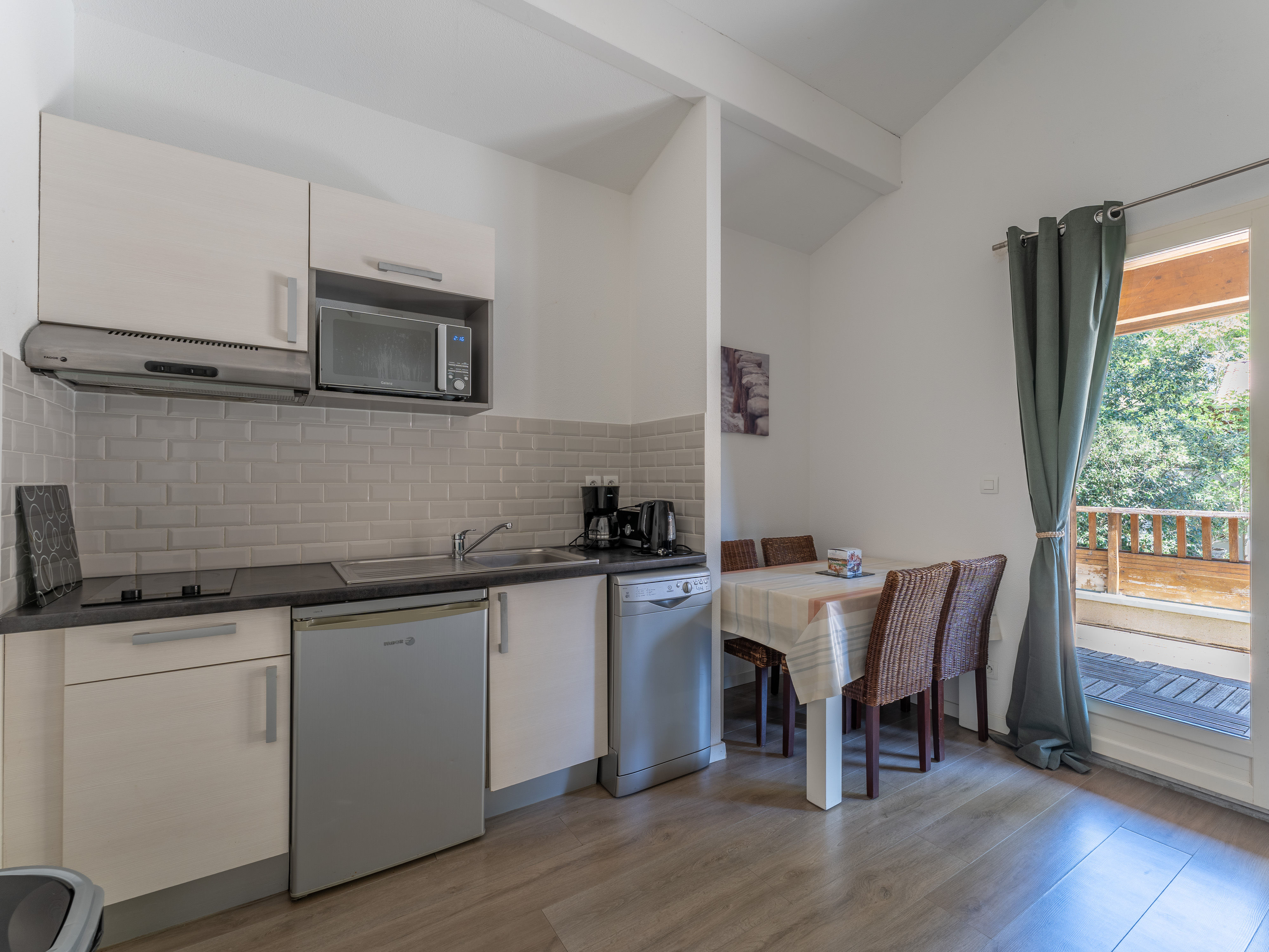 image The well-equipped kitchenette with ceramic hob, microwave, dishwasher and coffee maker — everything needed to make the most of your stay in the heart of the Lacanau pine forest.