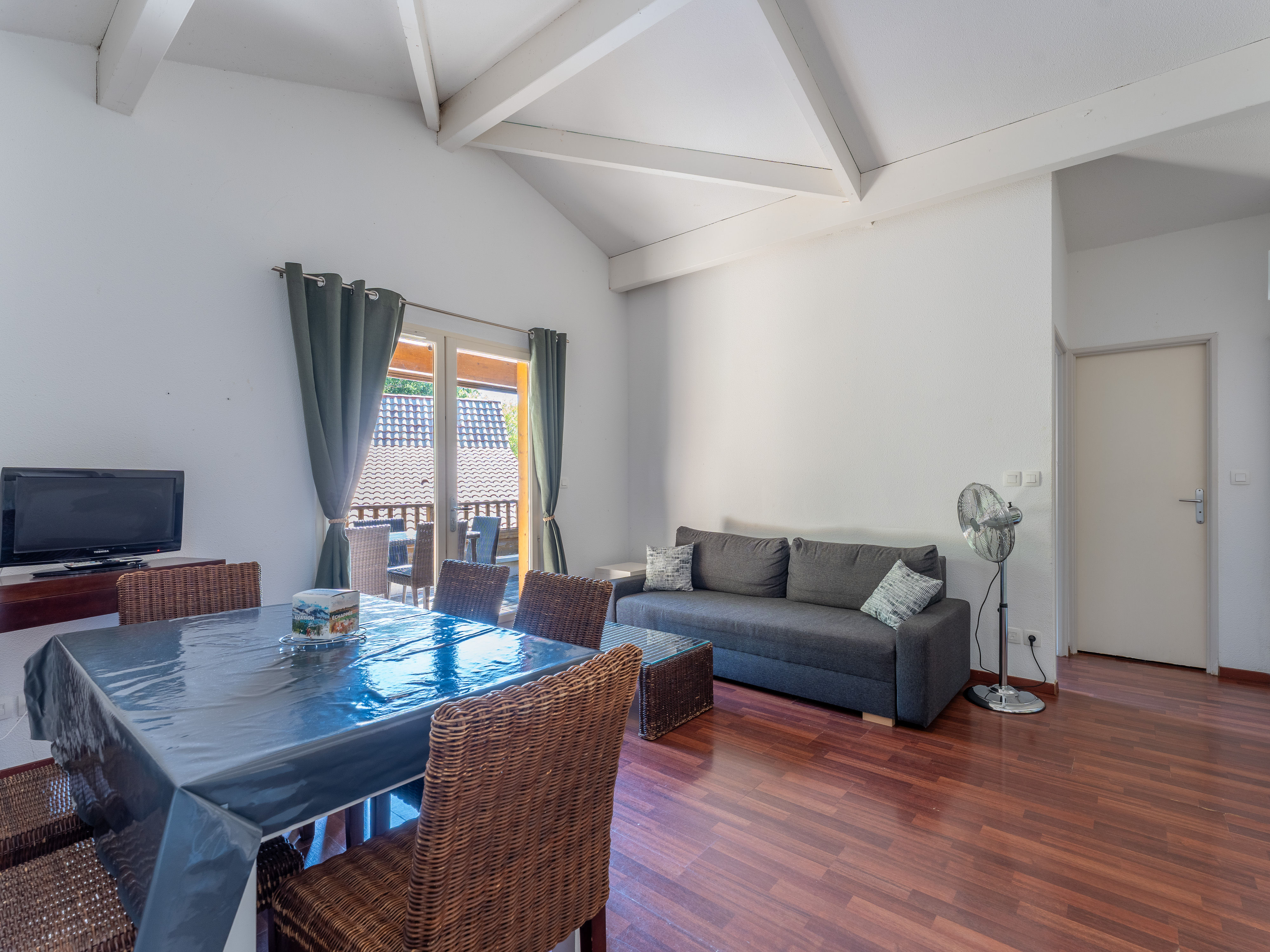 image The warm, characterful living and dining area of this triplex apartment, where rich timber floors and open-plan layout create a welcoming space for the whole group.
