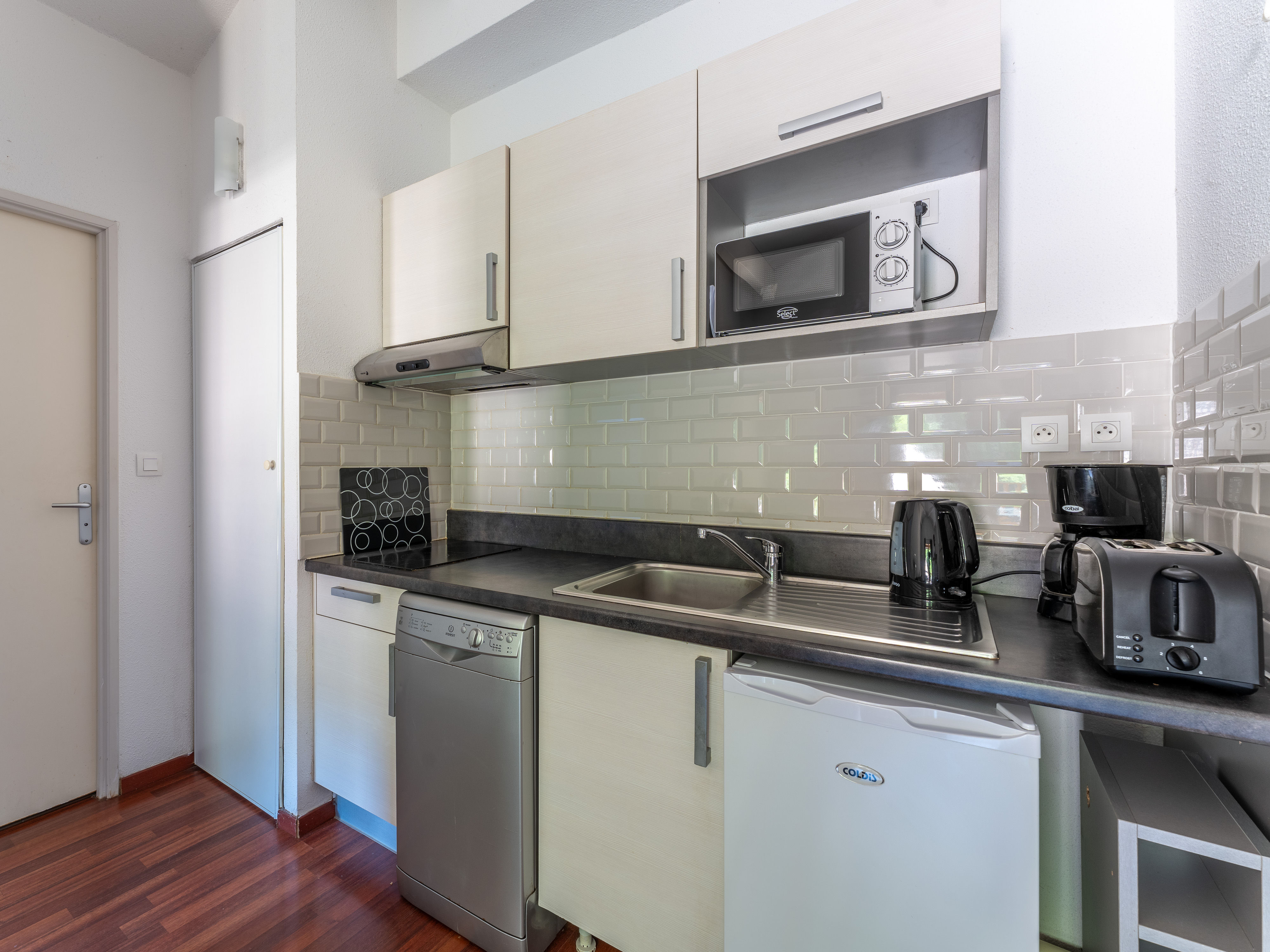 image The well-equipped kitchenette with ceramic hob, microwave and dishwasher — all you need to settle in and enjoy the rhythm of lake life at Les Rives du Lac.