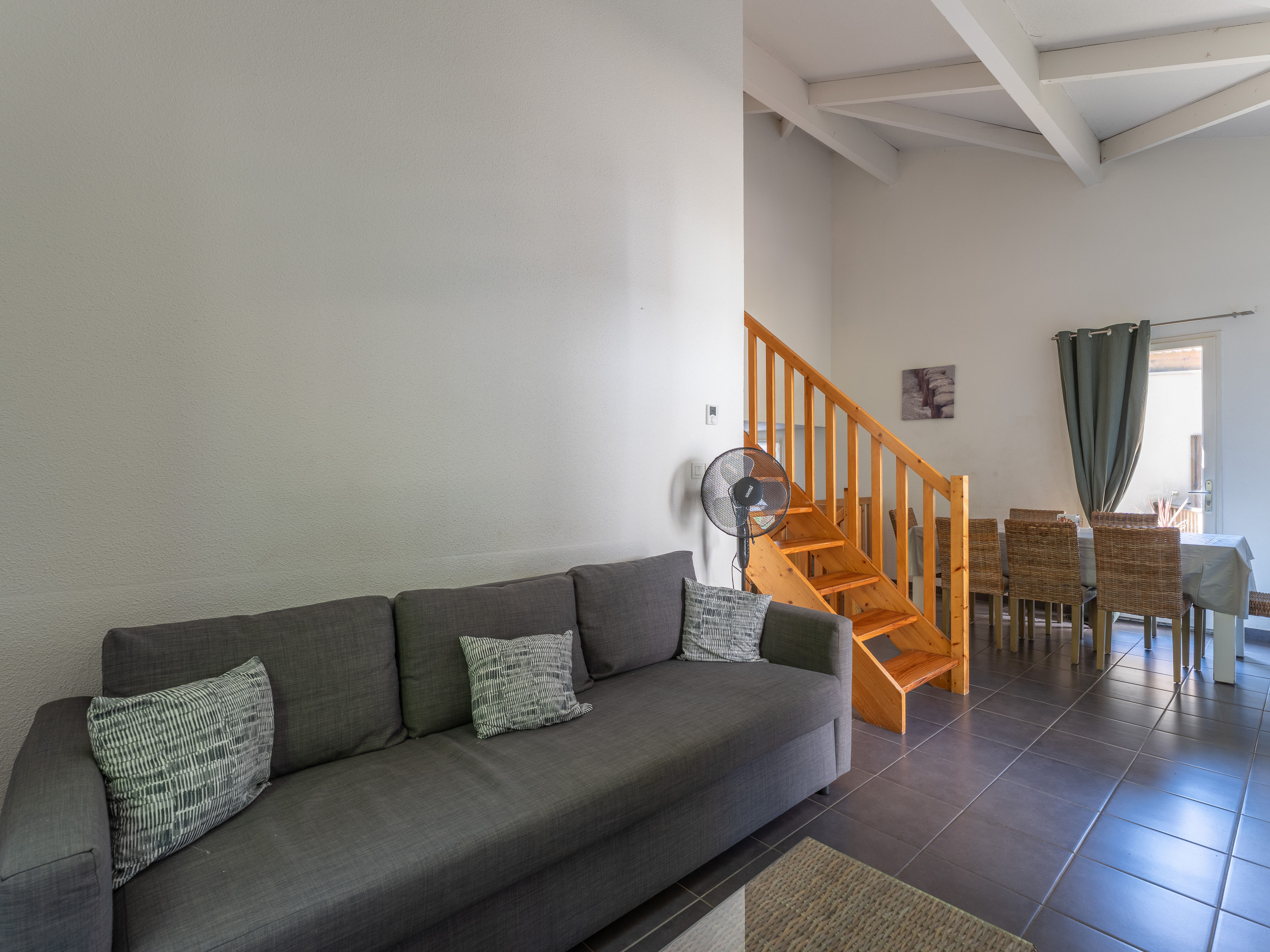 image The spacious living area with sofa bed and staircase leading to the upper levels — a generous, multi-level layout designed for groups and families of up to eight.