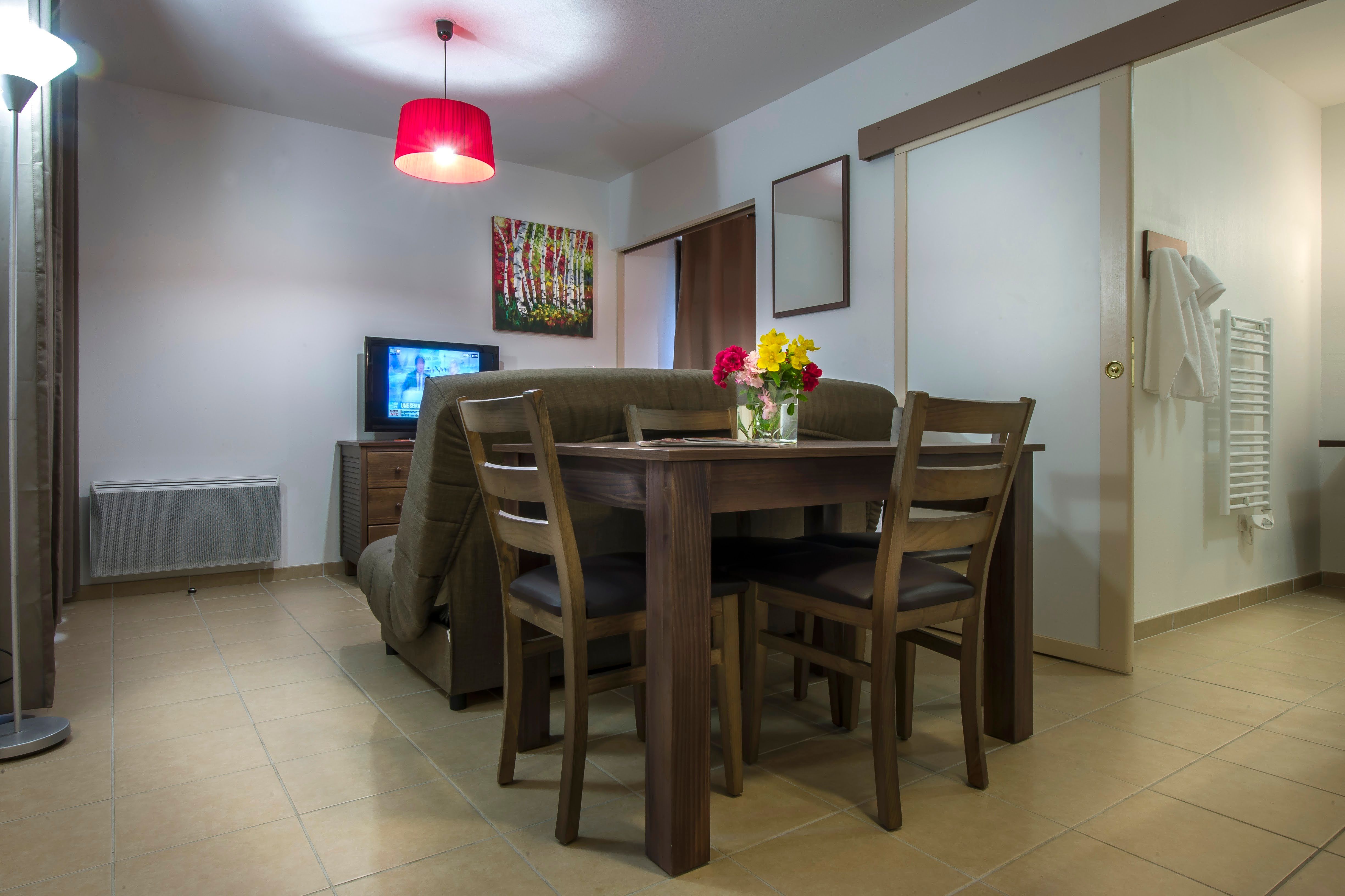image Cosy dining area with seating for four and warm ambient lighting.