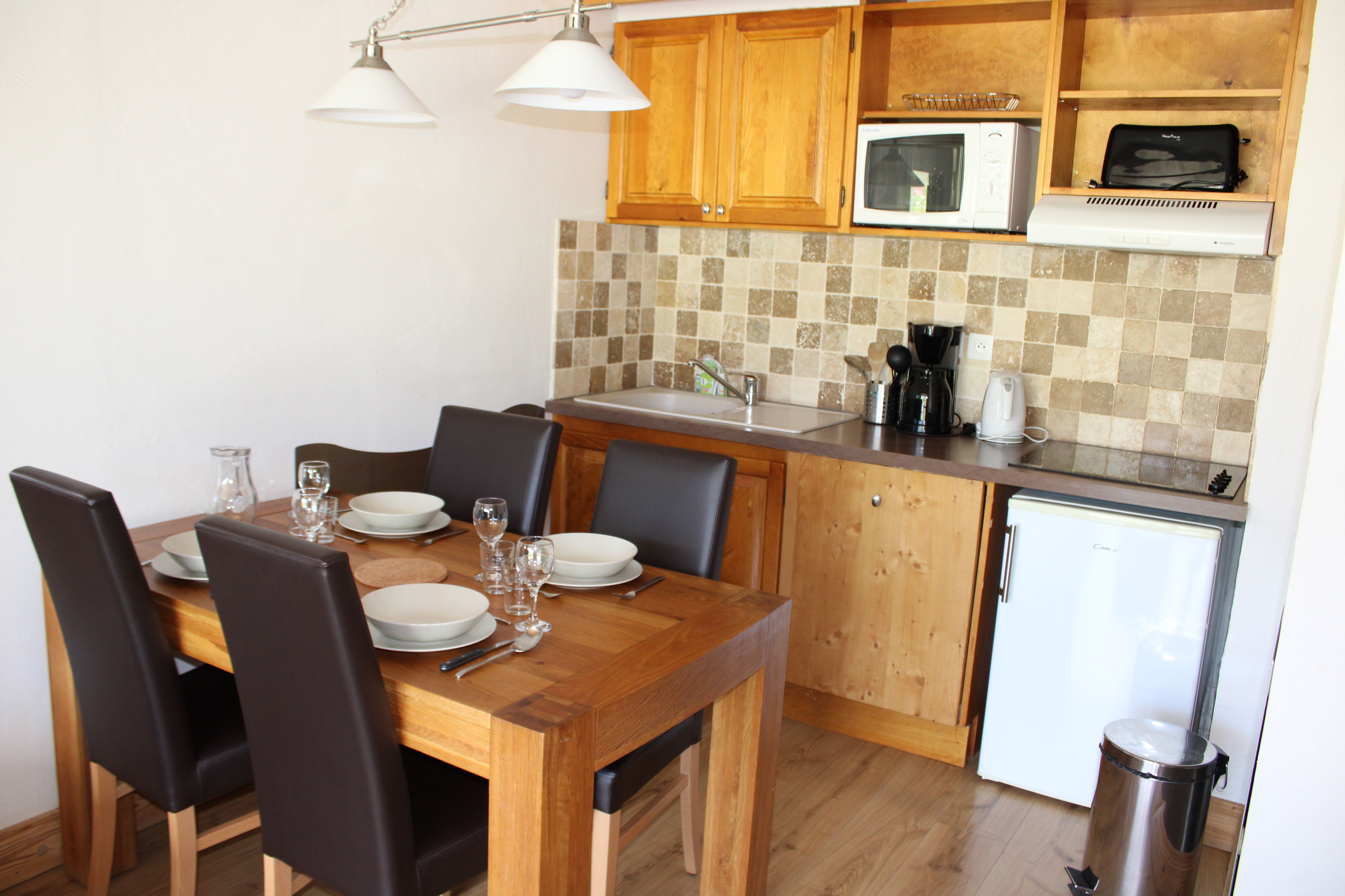 image Kitchen with microwave, coffee maker and a dining table for four.