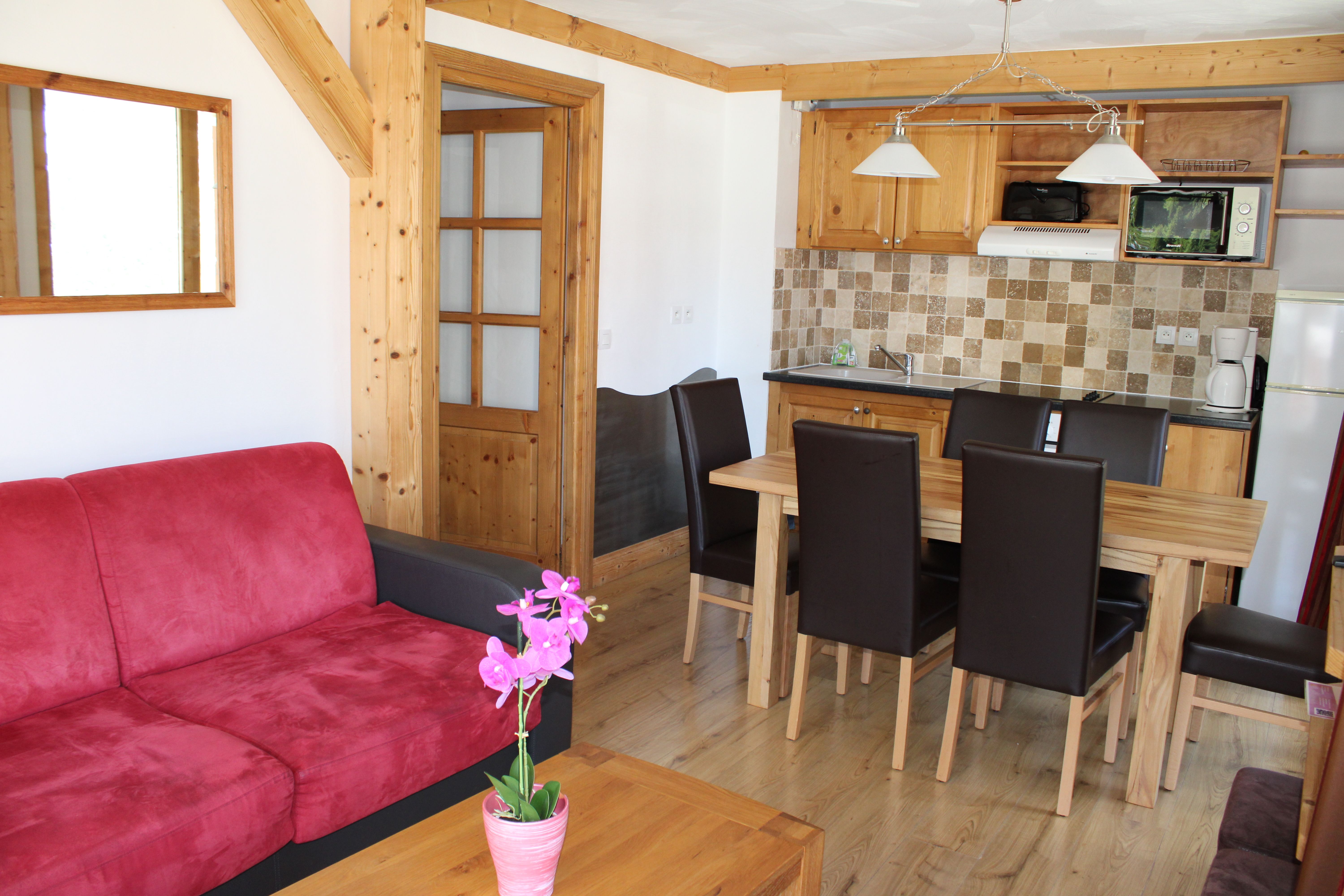 image Living area with sofa bed for two, dining table and an equipped kitchen.