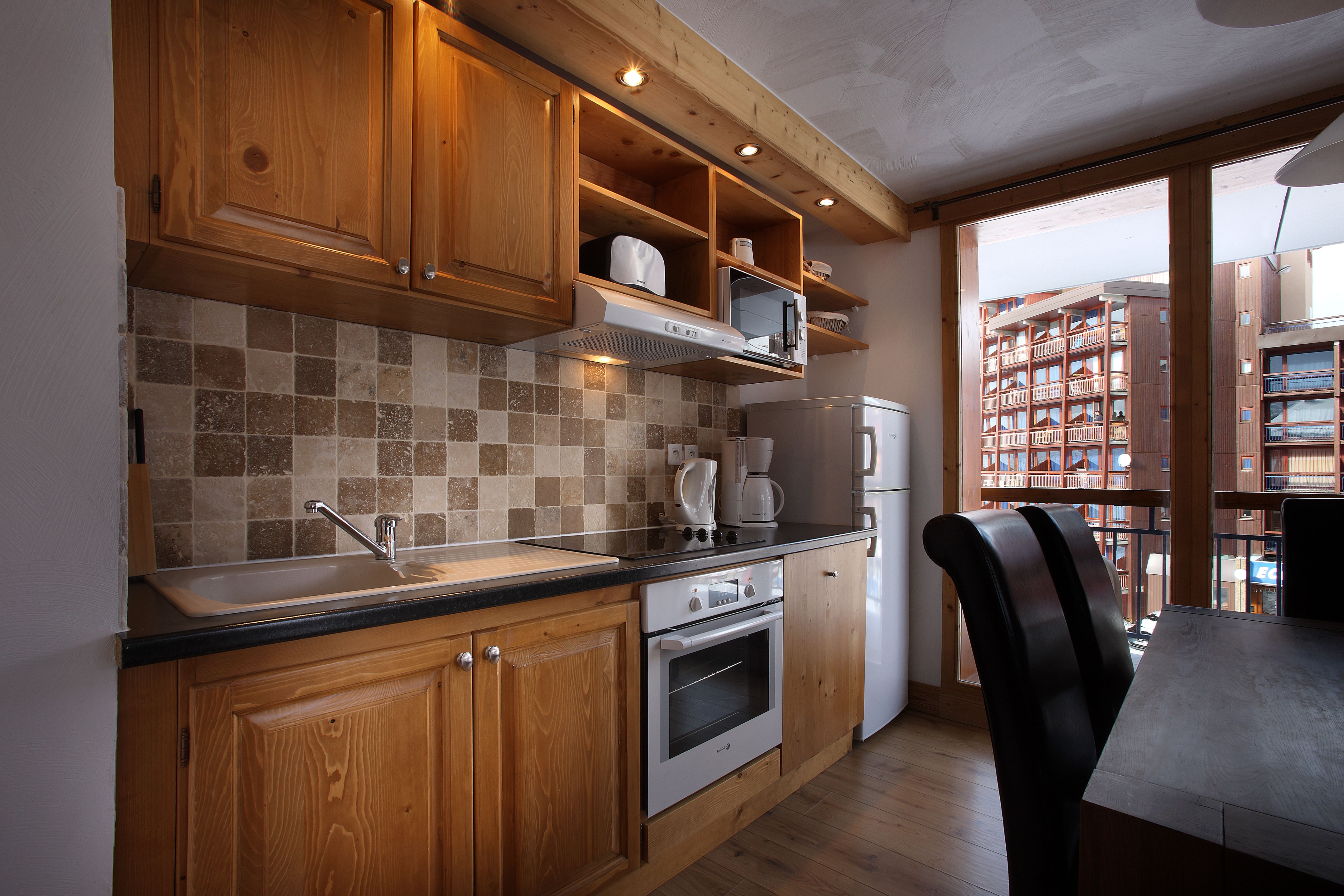 image Equipped kitchen with oven, toaster and microwave.