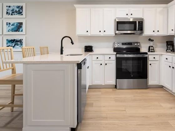 image White kitchen with stainless steel appliances, dishwasher, coffee machine, and full counter space