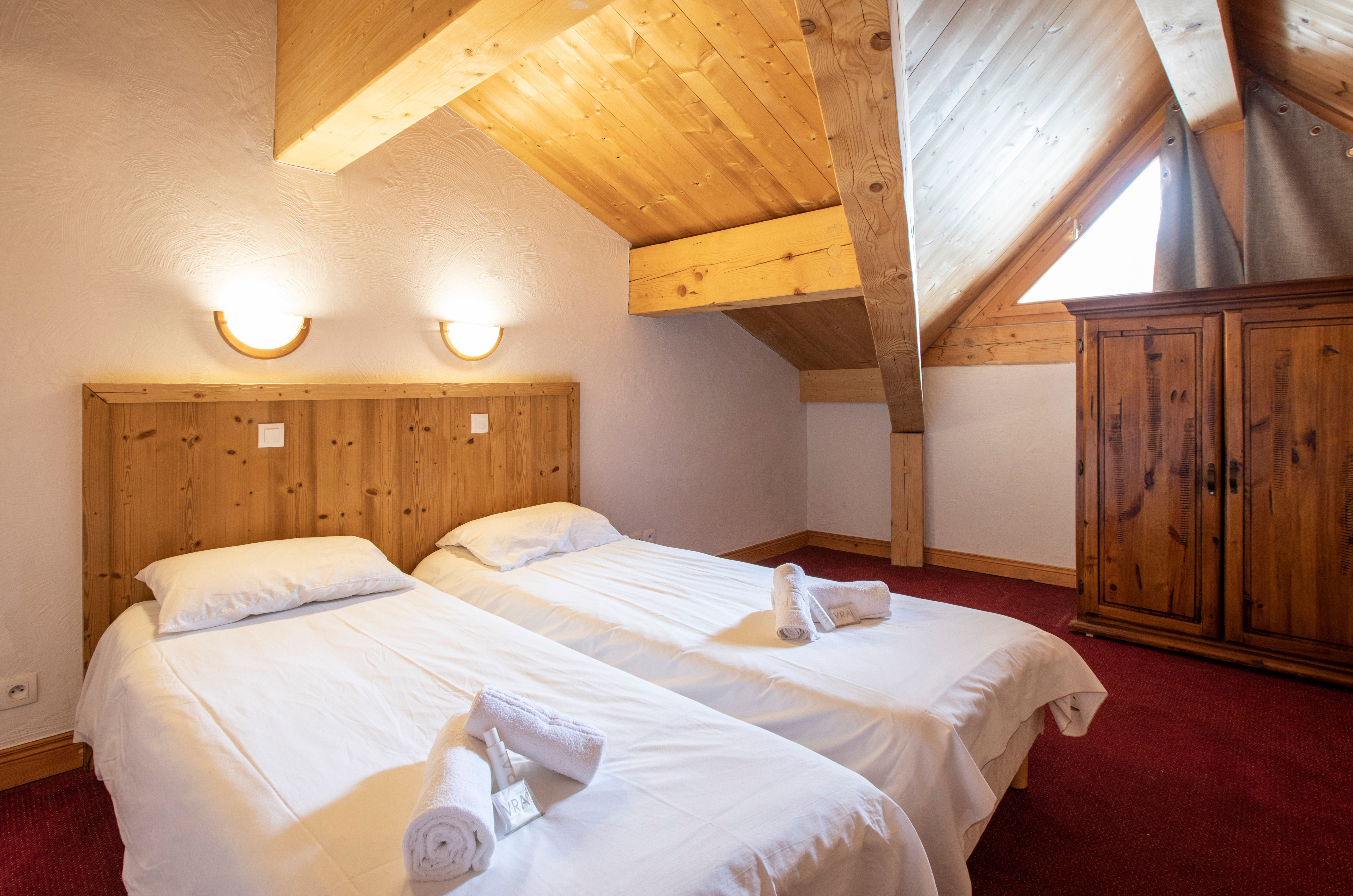 image Single beds under a cosy wooden ceiling.