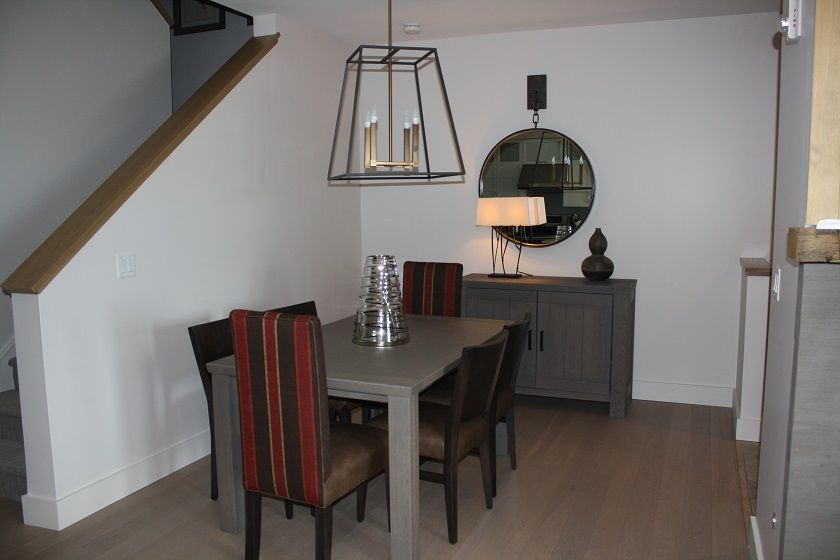 image Gather around the intimate dining table set beneath modern pendant lighting.