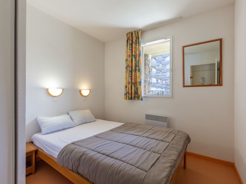 image The serene bedroom offers a restful retreat, complete with natural light and cozy furnishings.