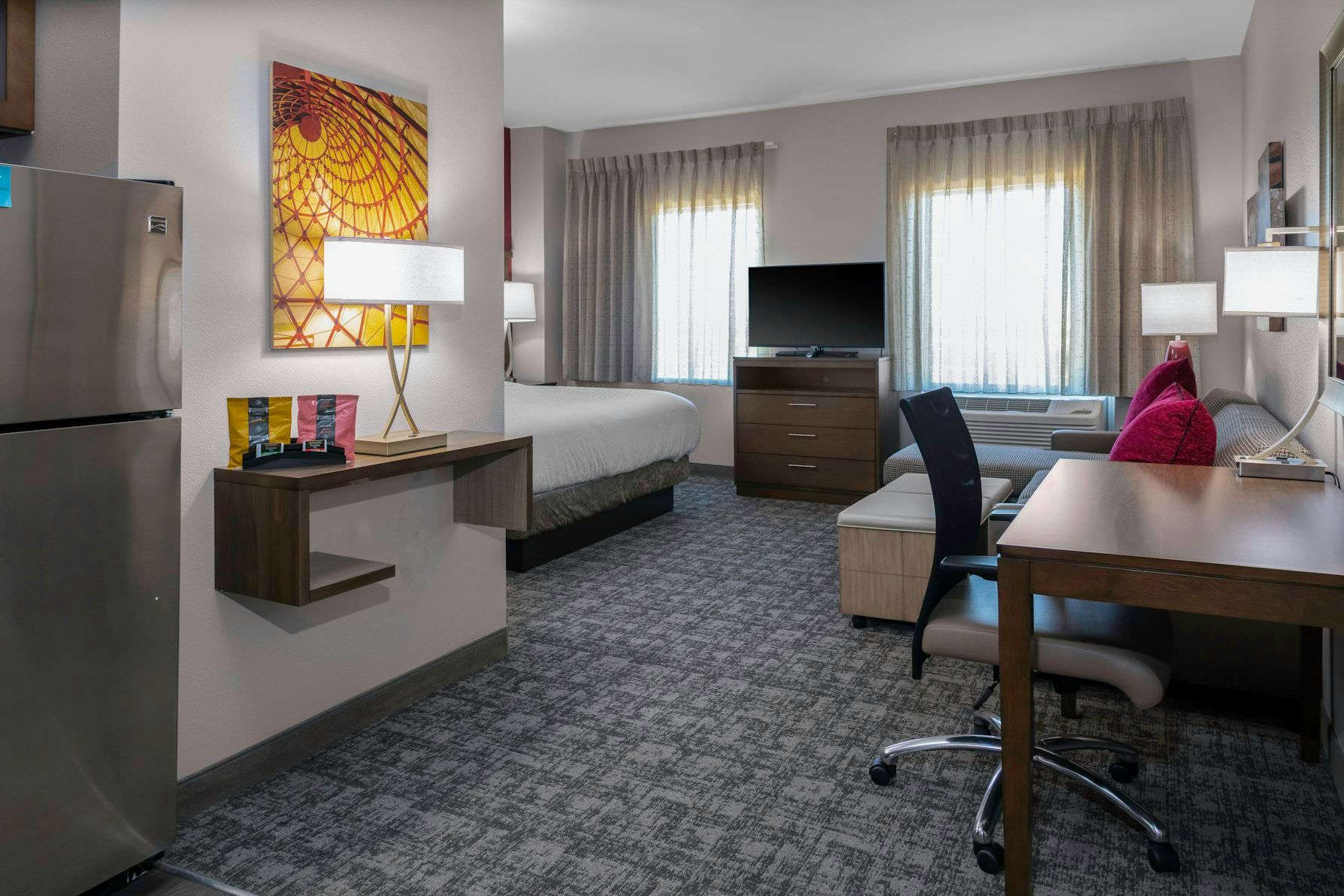 image Relax in a cozy studio featuring a king bed, stylish decor, and natural light streaming through the large windows.