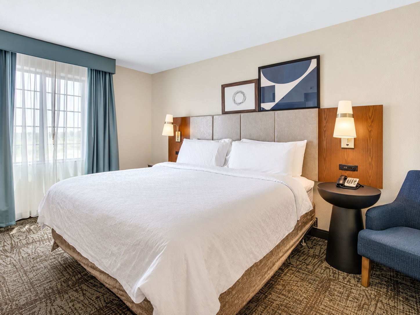 image Plush bedroom with a king bed, bedside lamps, and an armchair.