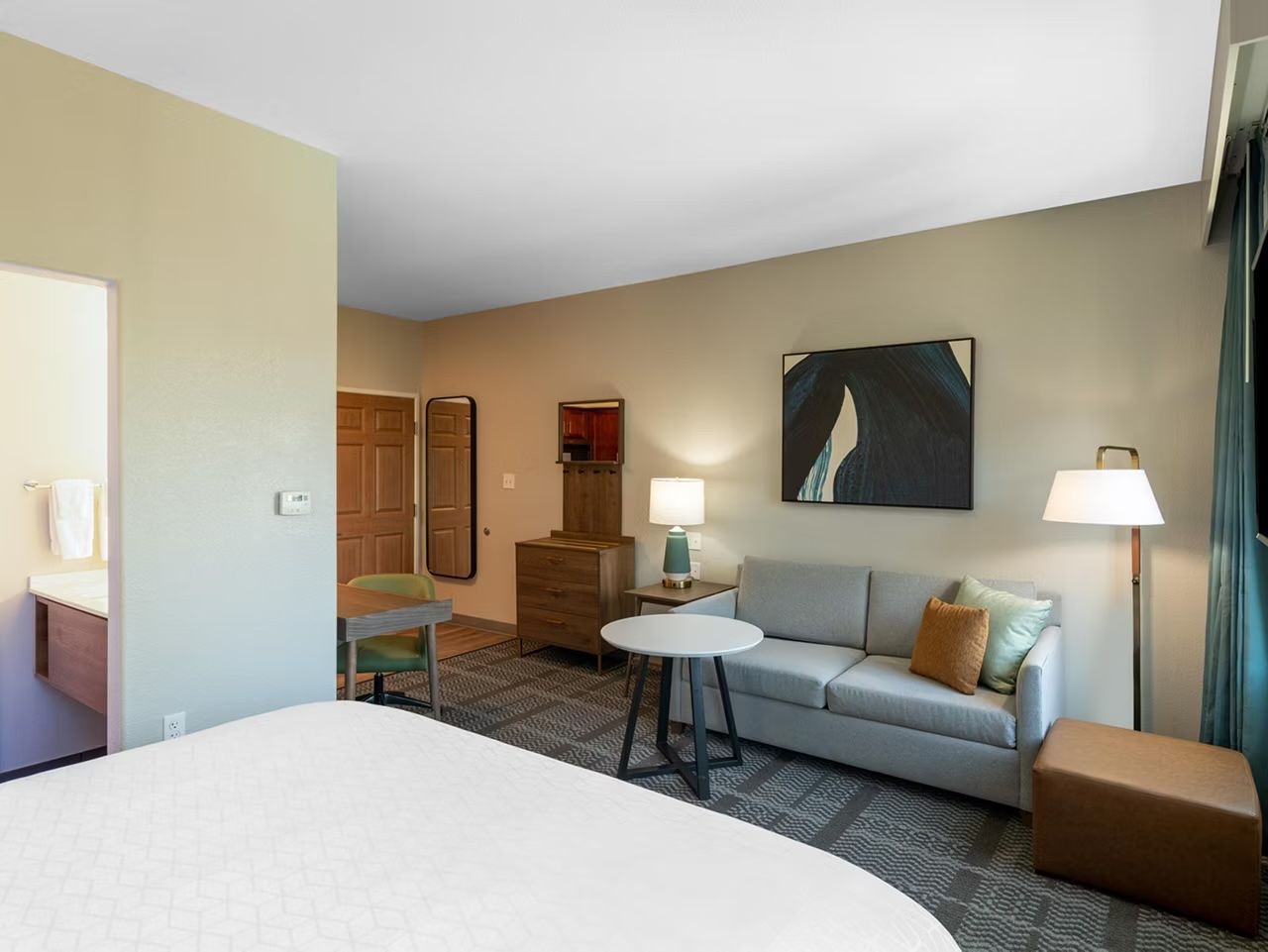 image King bed and sofa with a round dining table — bathroom is steps from the seating area